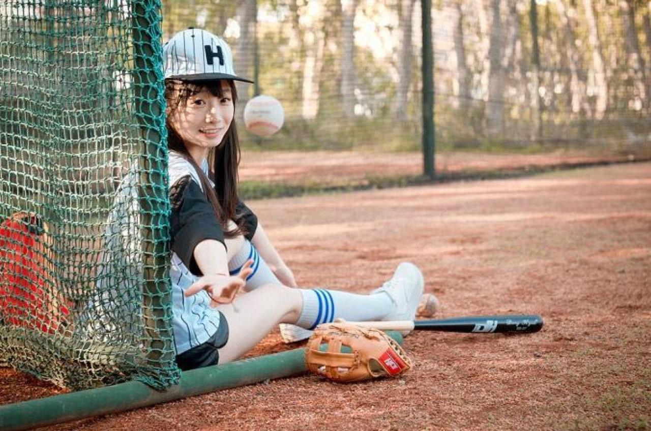 馋宝宝靠在棒球网上，把棒球抛起