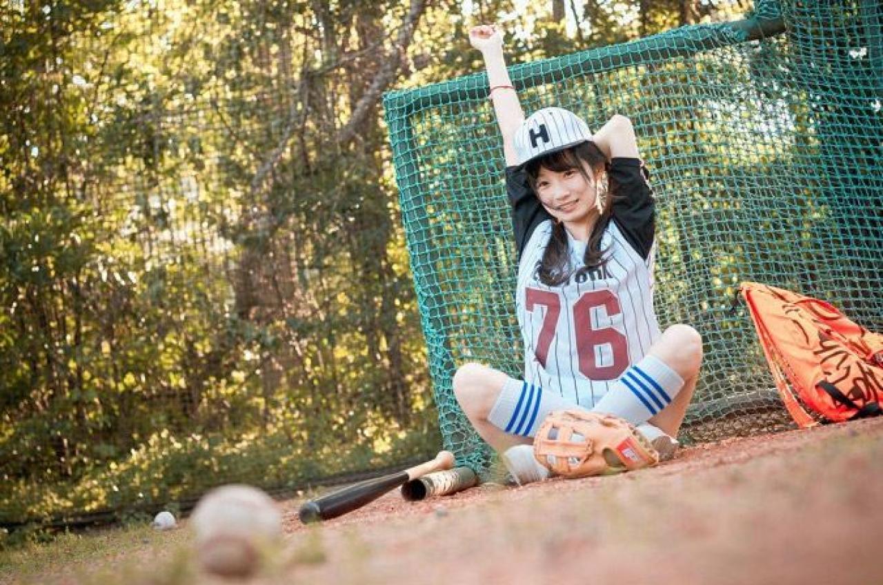 馋宝宝靠在棒球网上左手放在脑后，右手伸直，靠坐在棒球网上的姿势