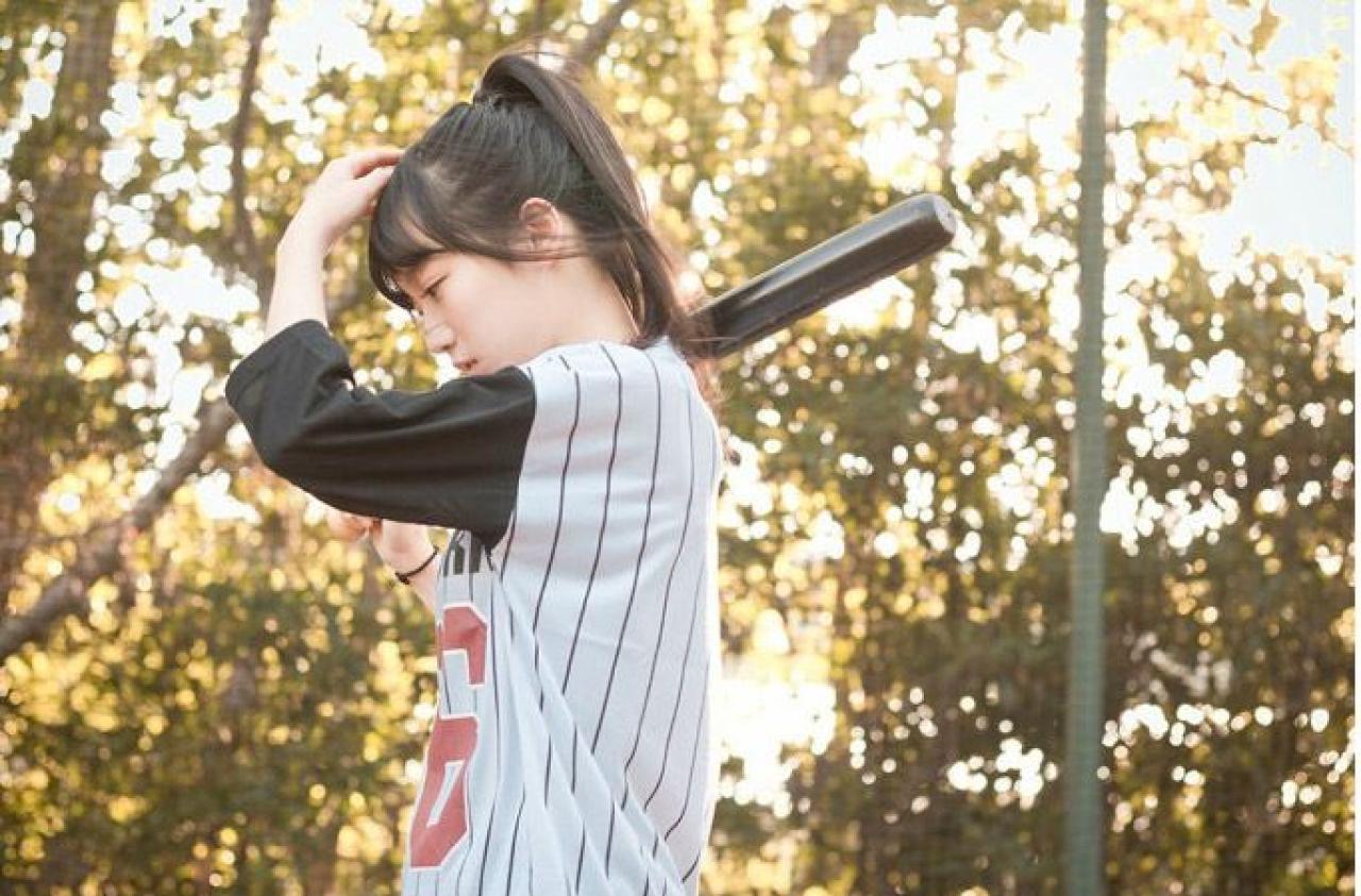 馋宝宝扛着棒球棒，低这头摸着头发侧面照