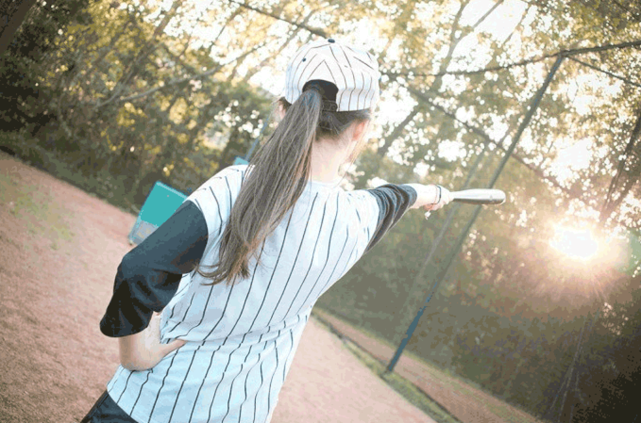 馋宝宝左手叉腰，右手拿着棒球棒直指前方的背面照