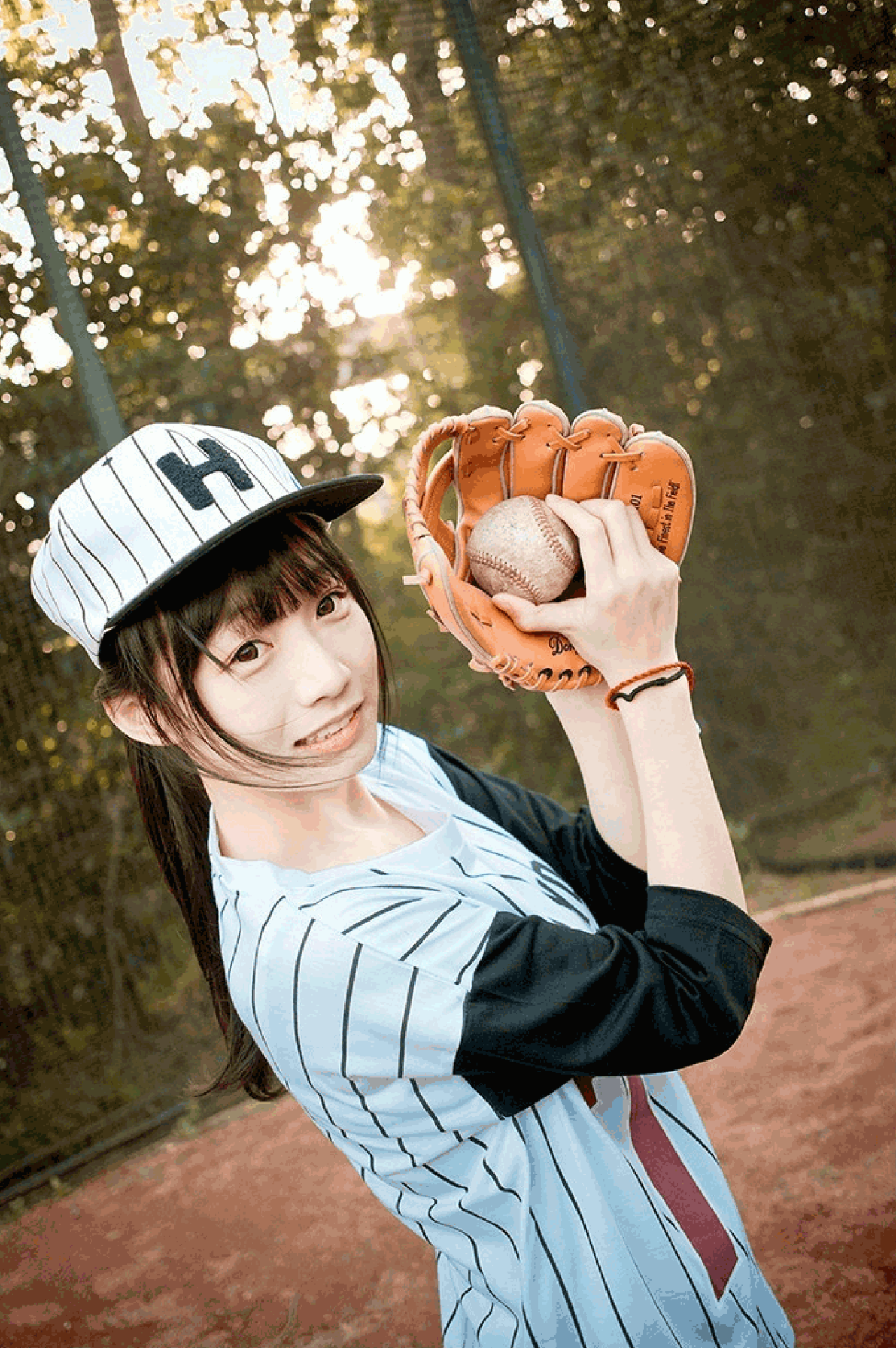 馋宝宝展示戴着棒球手套握球的侧面照