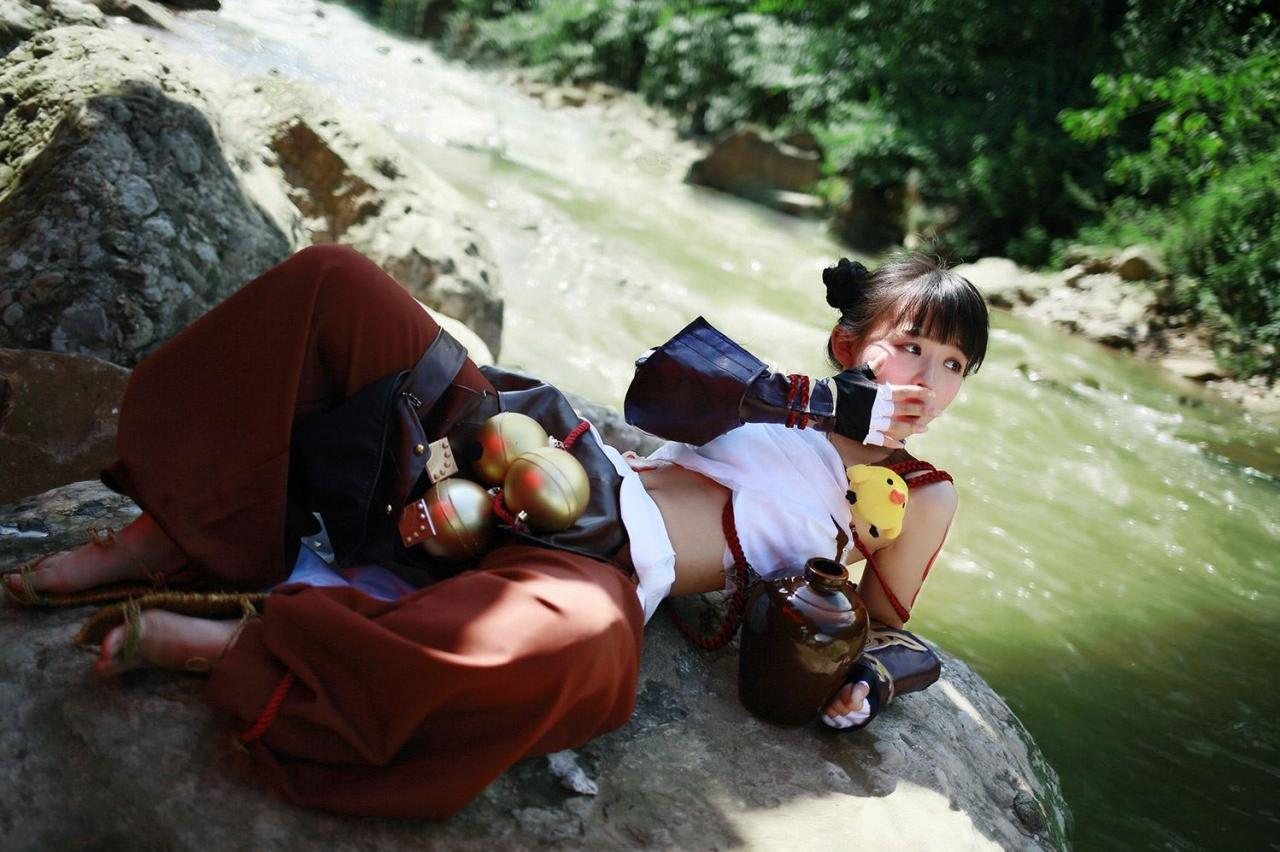 修老虎扮演丐帮萝莉懒洋洋的坐在石头上，一手捂着嘴打哈欠