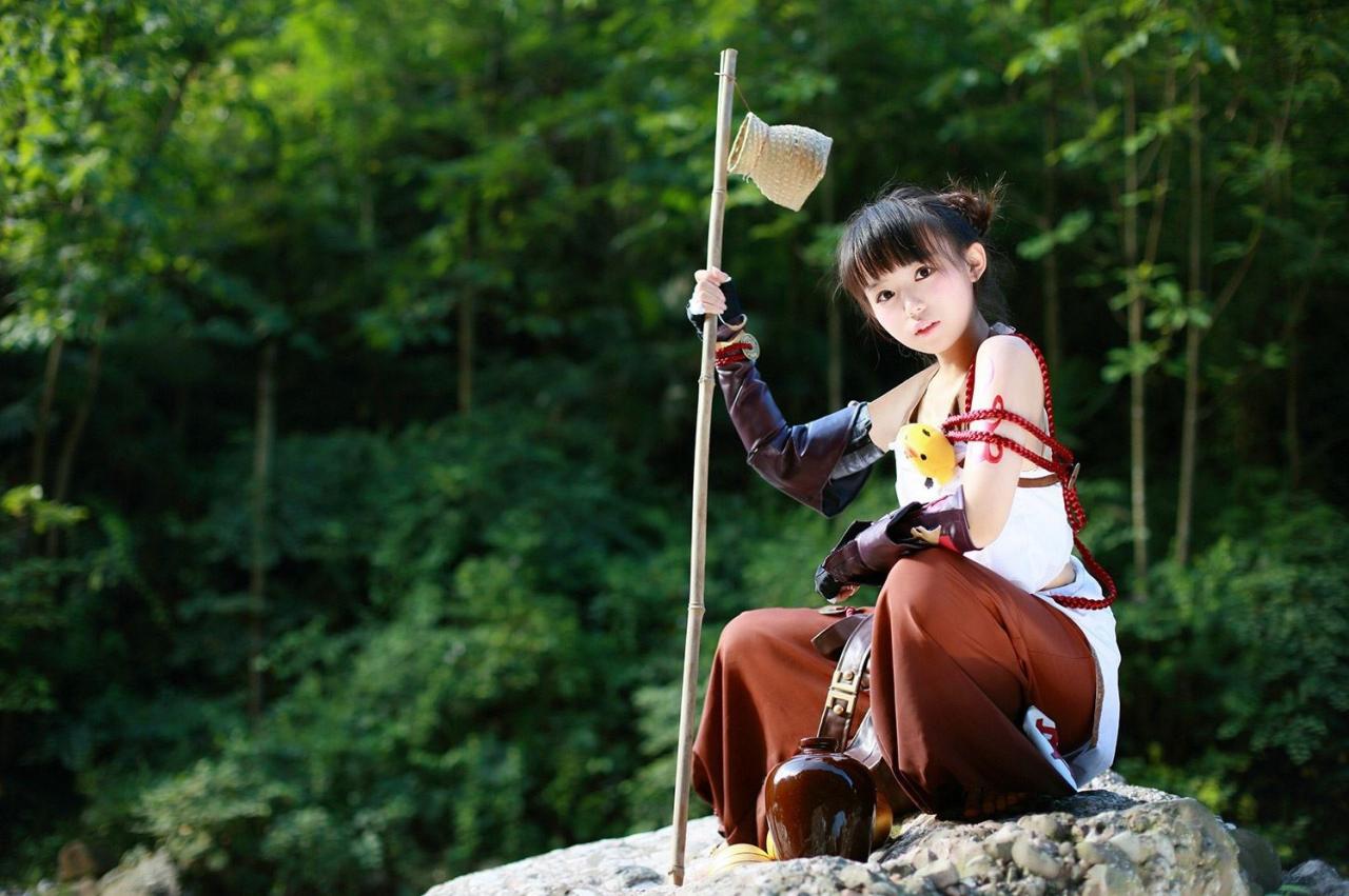 修老虎扮演丐帮萝莉拿着吊着半个罐子的竹竿坐在石头上右侧视角照