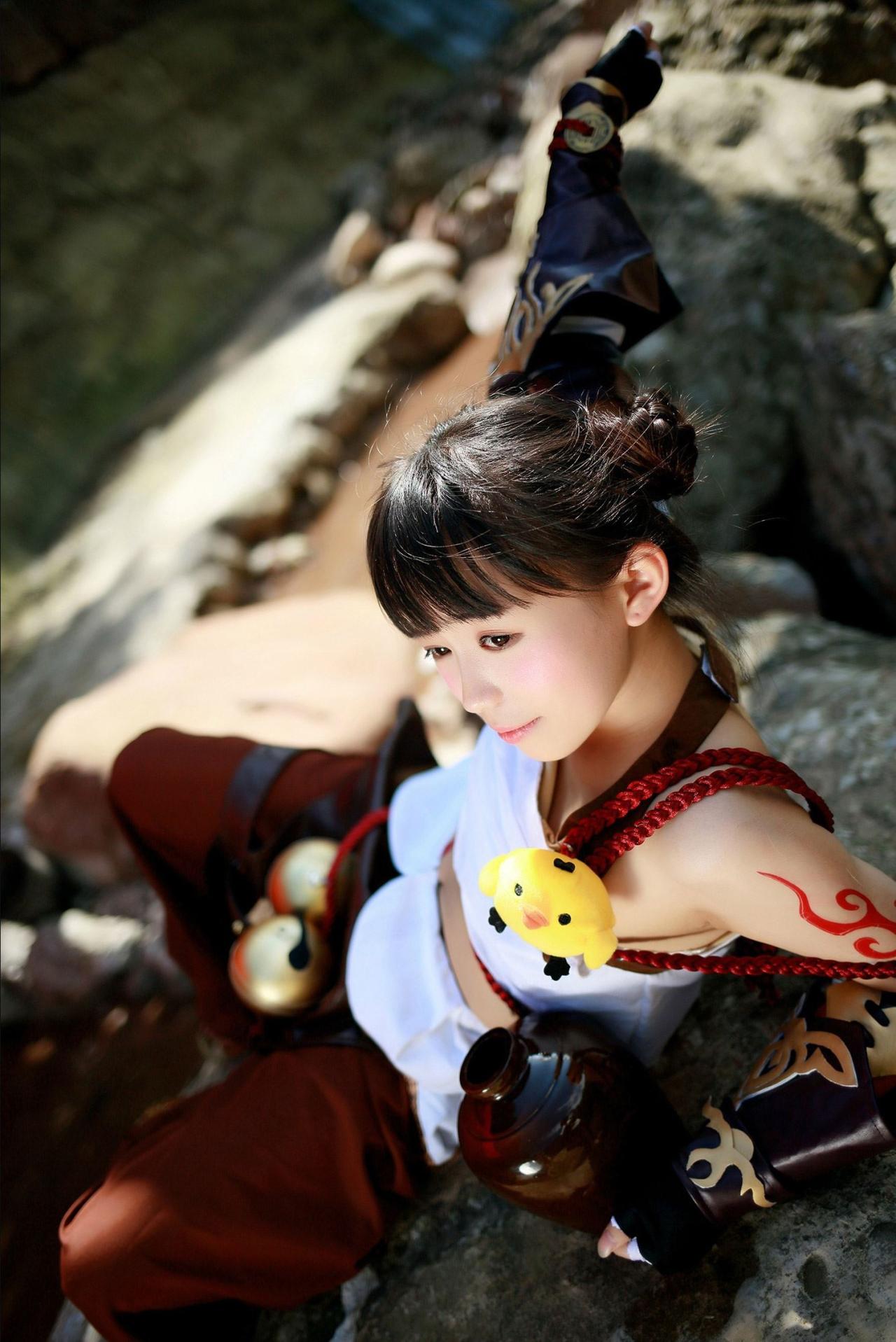 修老虎扮演丐帮萝莉靠在石头上，左手弯曲，右手伸展