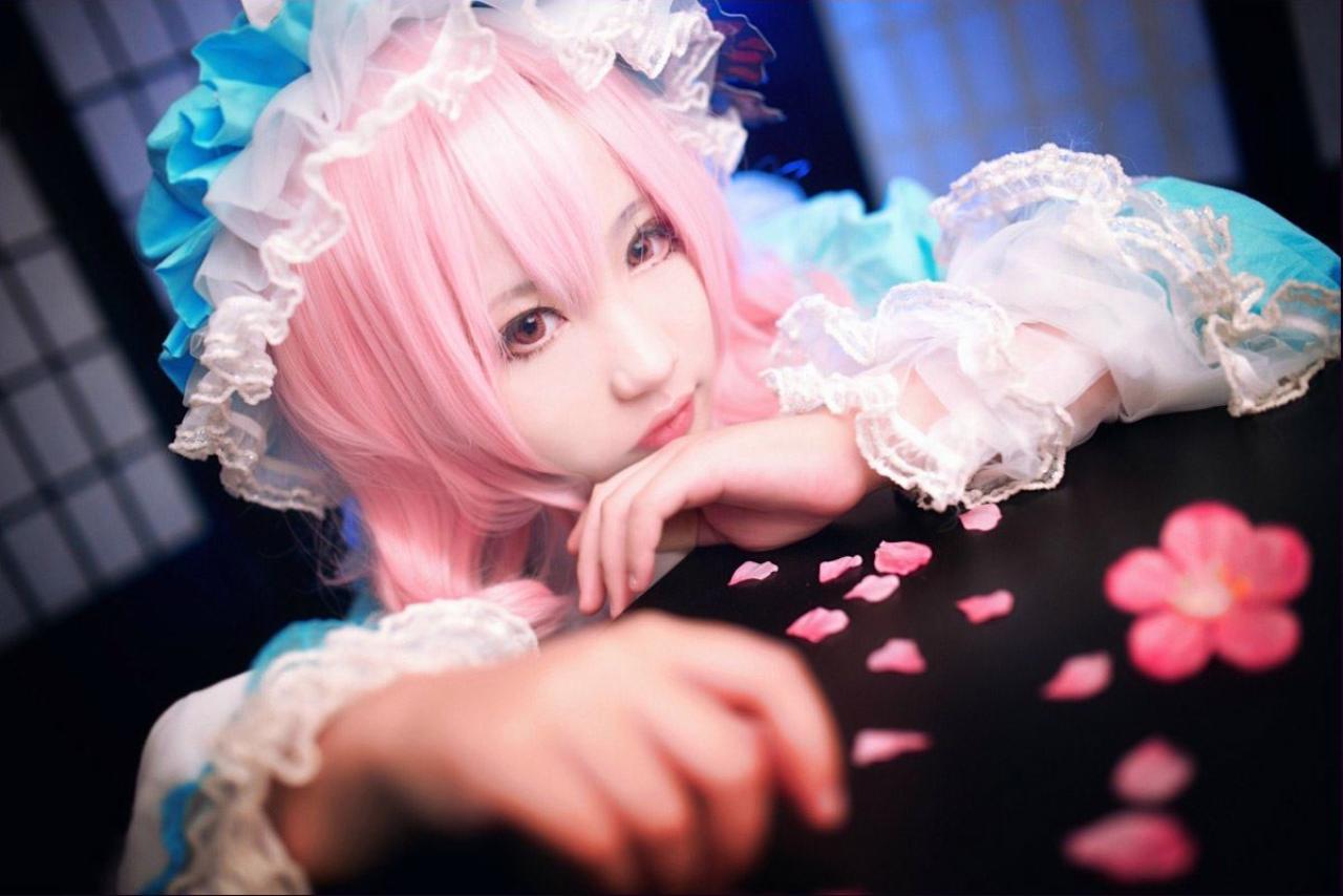 小番茄扮演西行寺幽幽子扒在桌子上，桌子上撒着零星被撕开的花瓣