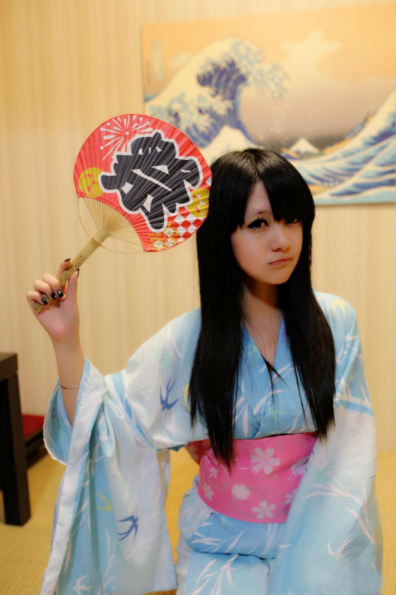 小蓝残无右手拿着扇子敲自己的头，嘟嘴卖萌的模样