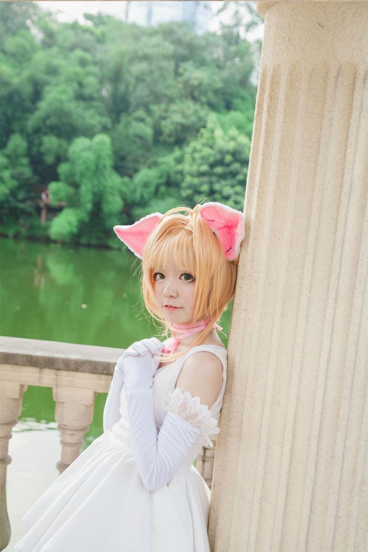 阿八扮演木之本樱靠在柱子上，双手抱拳放在胸前