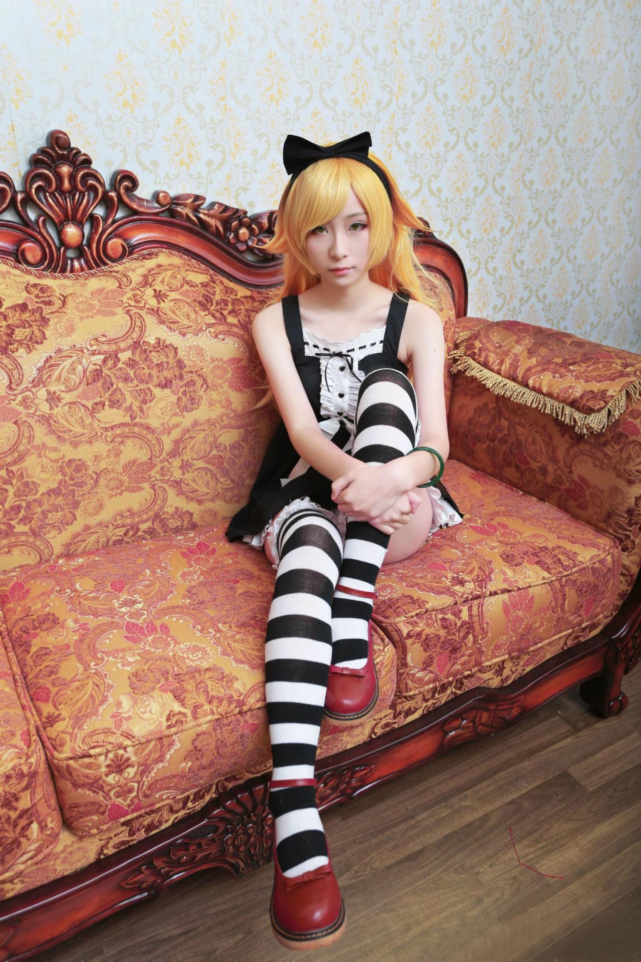 下北原喵扮演忍野忍抱着膝盖端坐在沙发上