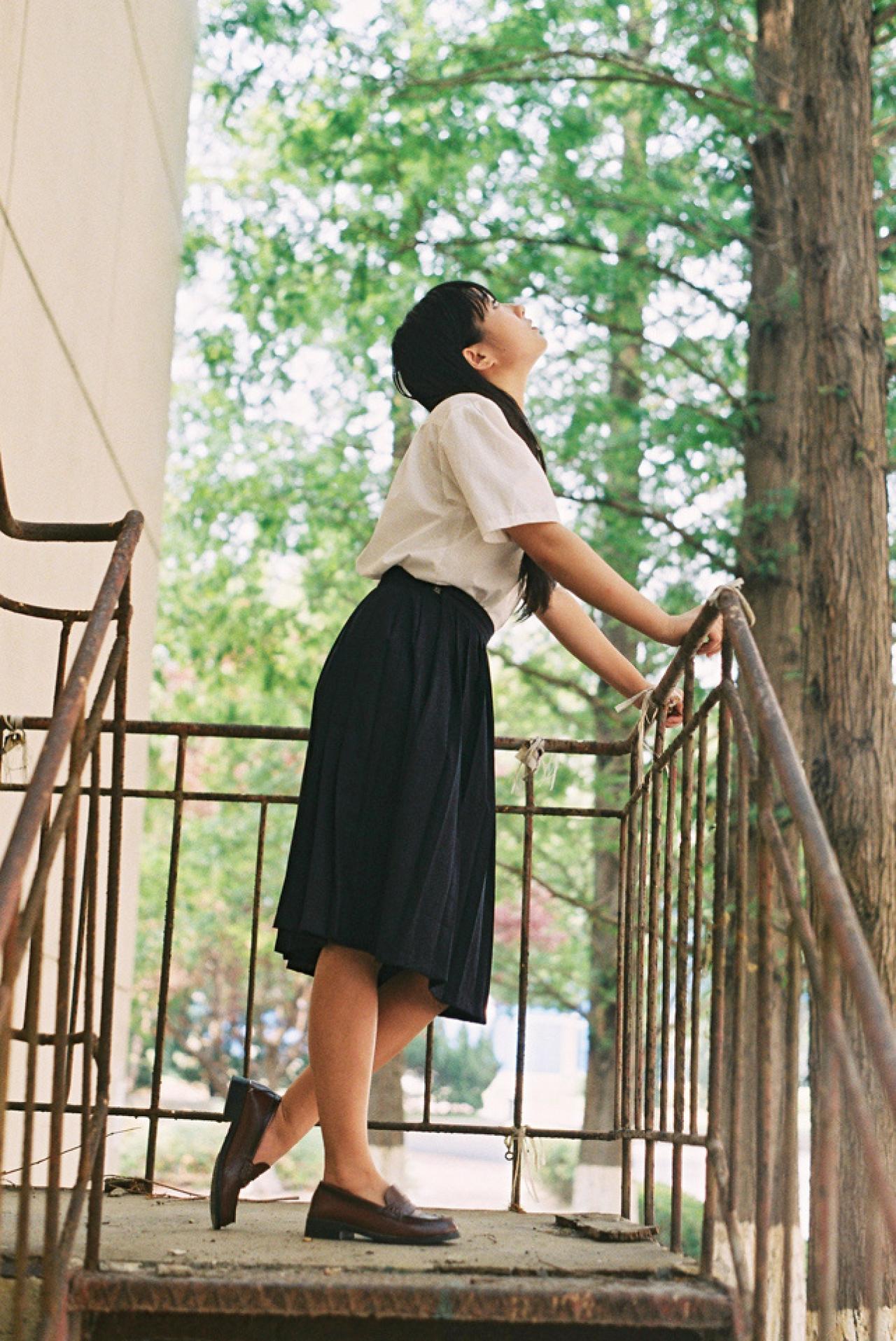 小陆离扒在铁锈栏杆上抬头仰望高大的树木