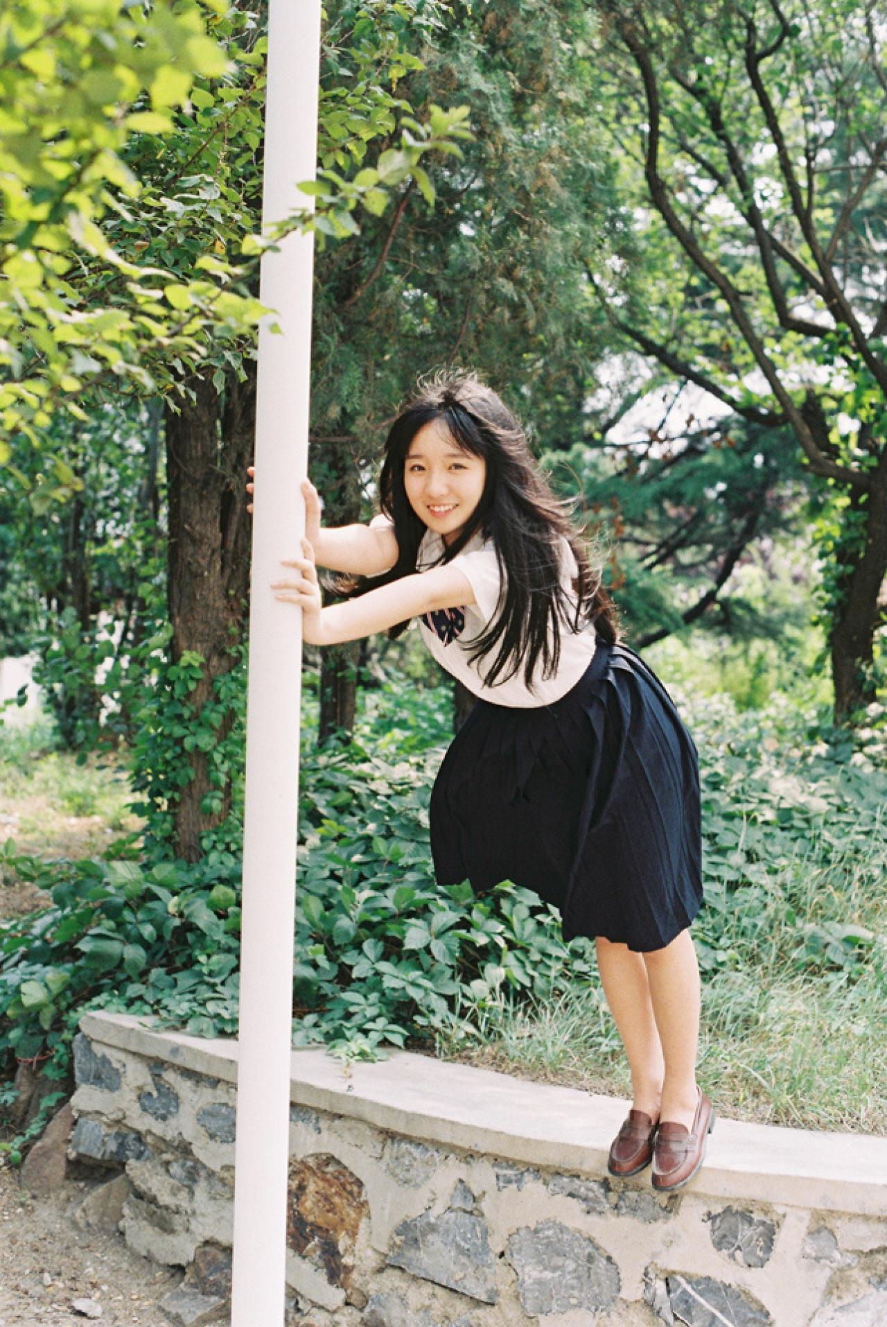 小陆离双手扒在杆子上微笑的样子