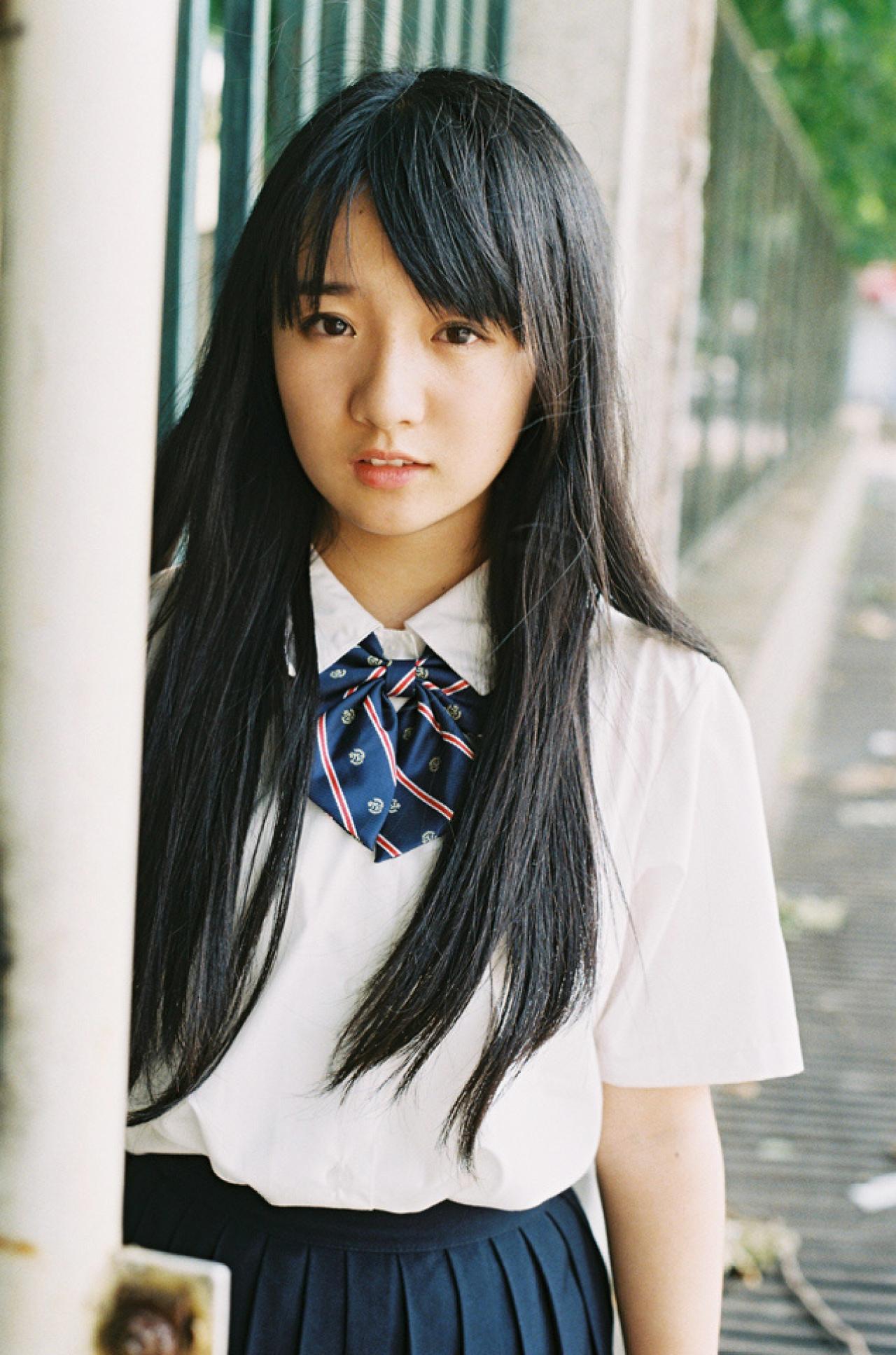 小陆离站在围墙立柱后，半张嘴露出一半门牙看着镜头