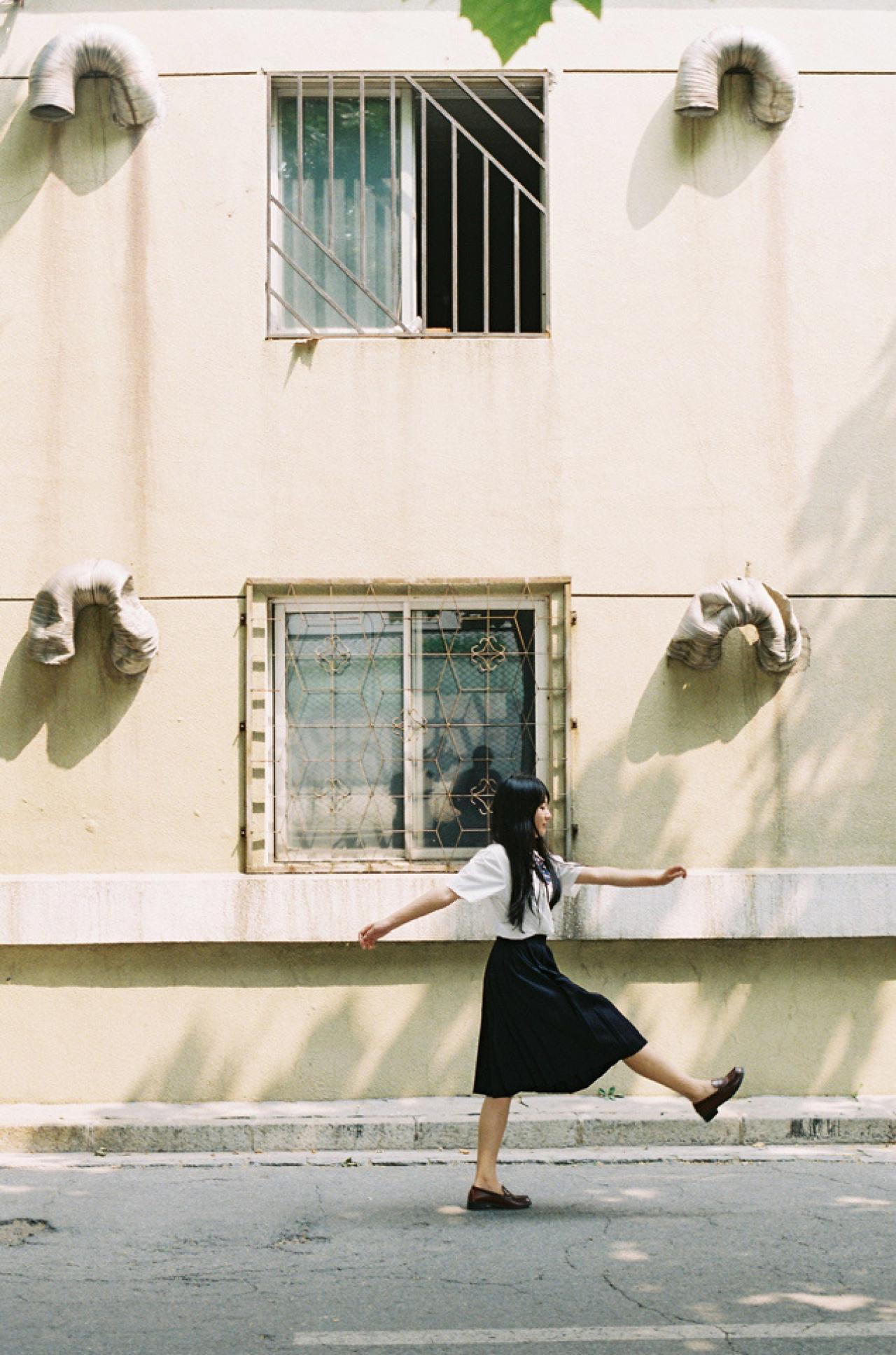 小陆离齐步走在斑驳的街道上的侧面照