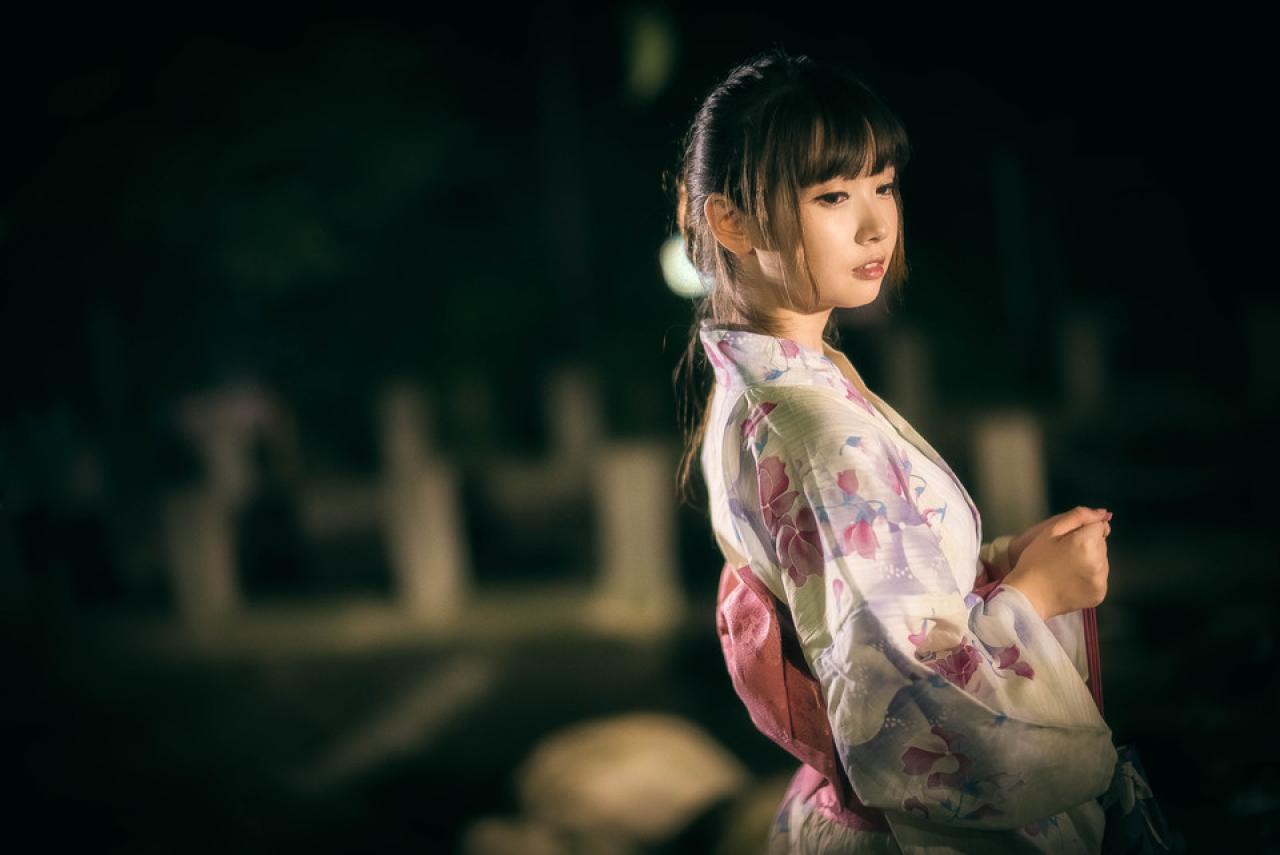 雪雪双手半握拳靠在一起，提着香袋的侧身看着右下方的横幅照