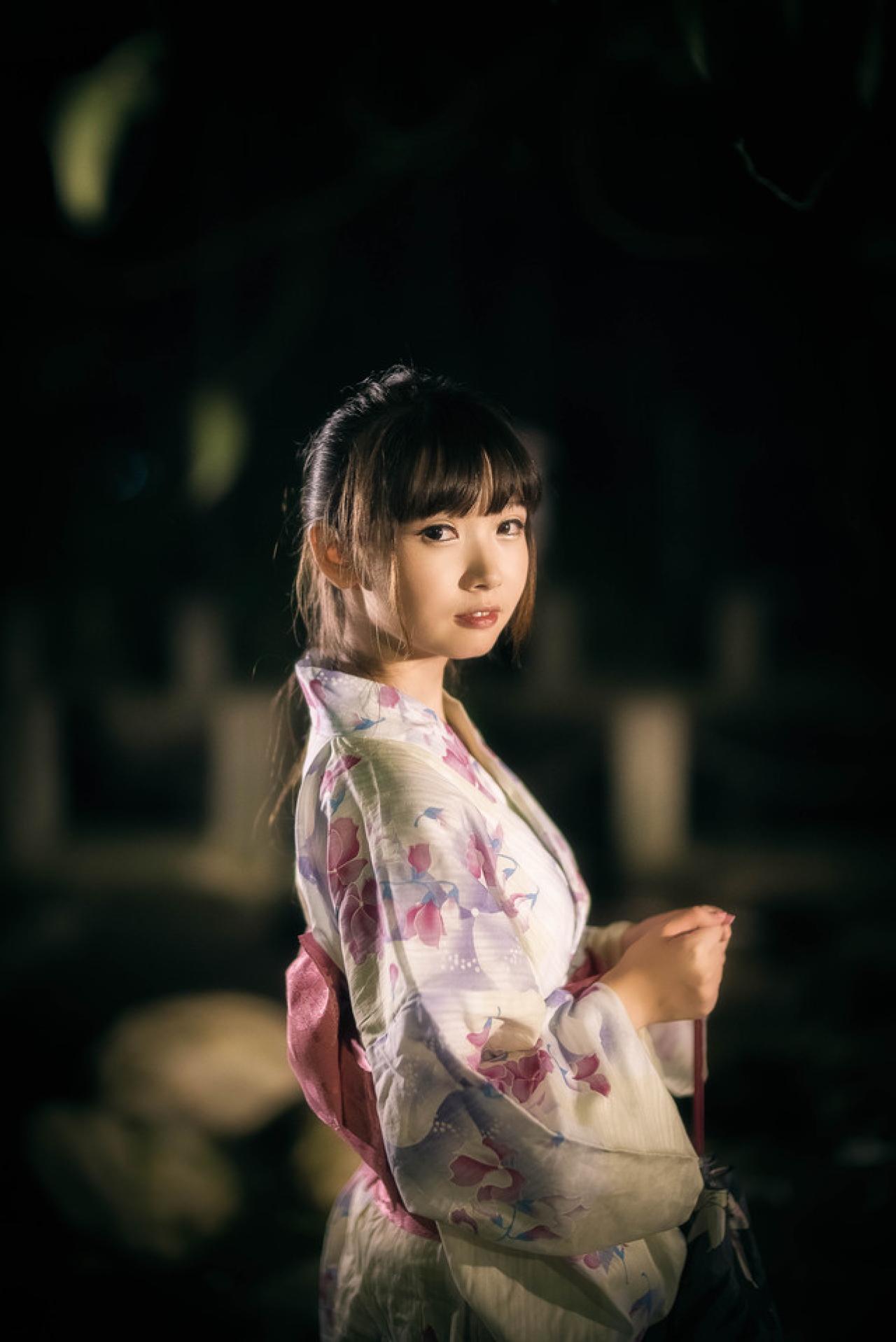 雪雪双手半握拳靠在一起，提着香袋的侧身回头看镜头的立幅照