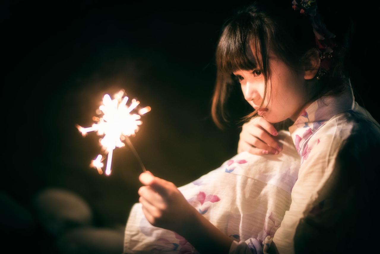 雪雪左手抱着膝盖，深深凝望着右手手中的仙女棒，露出孤独的神情