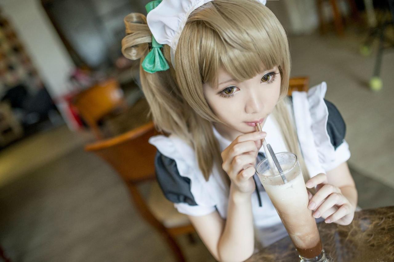 霜月扮演南小鸟坐在餐桌旁很认真喝着奶茶的样子