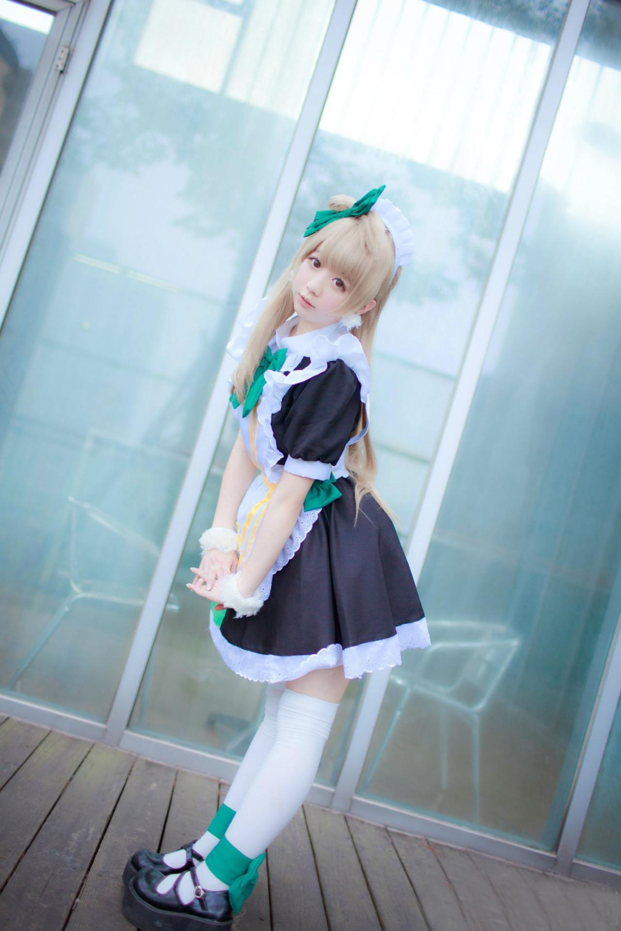 亚米扮演南小鸟双手五指交叉，叠放在一起，放到裙摆处，略微弯腰，萌萌的侧面照