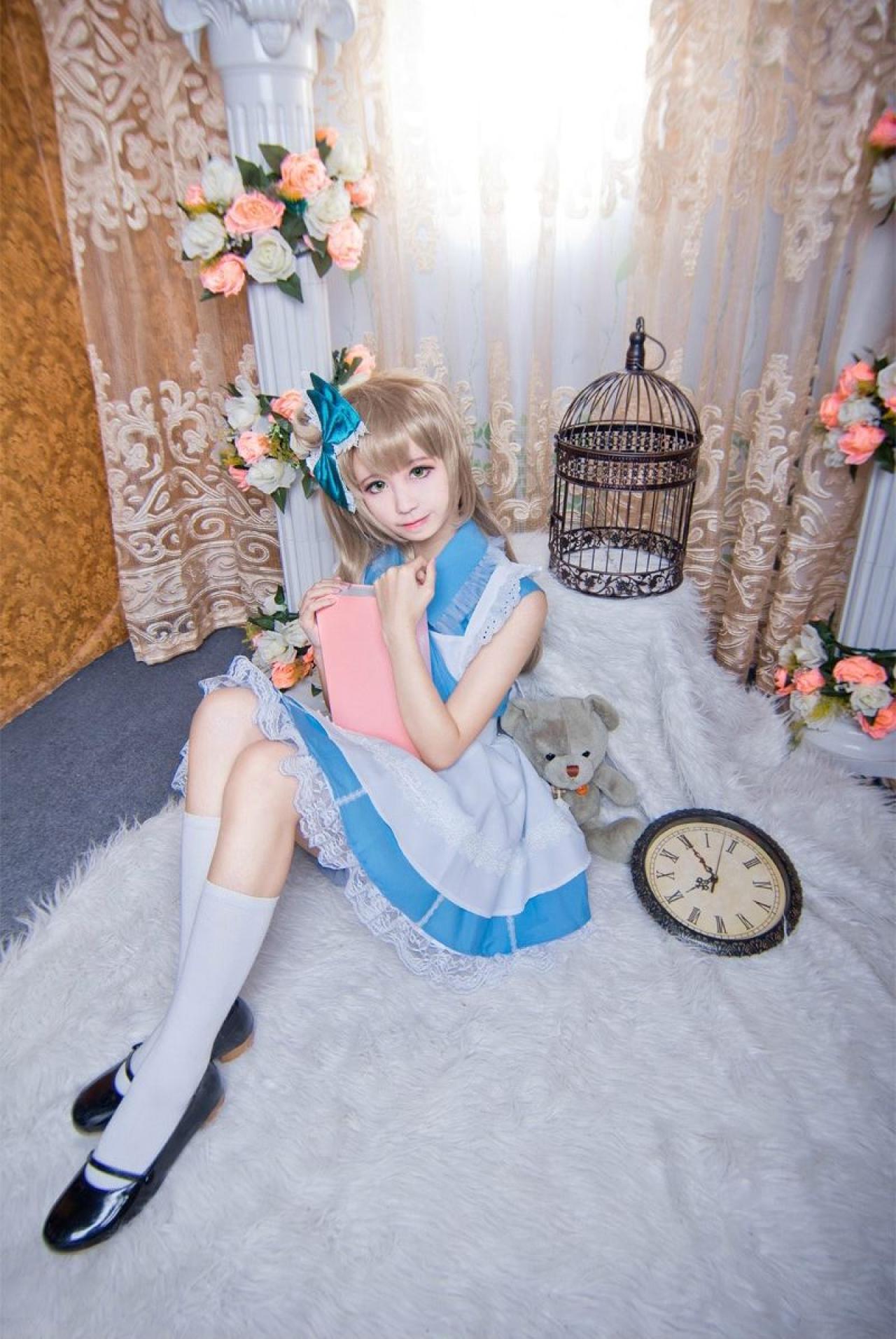 赤澤Aki扮演南小鸟抱着粉色夹子坐在毯子上，头偏向右侧