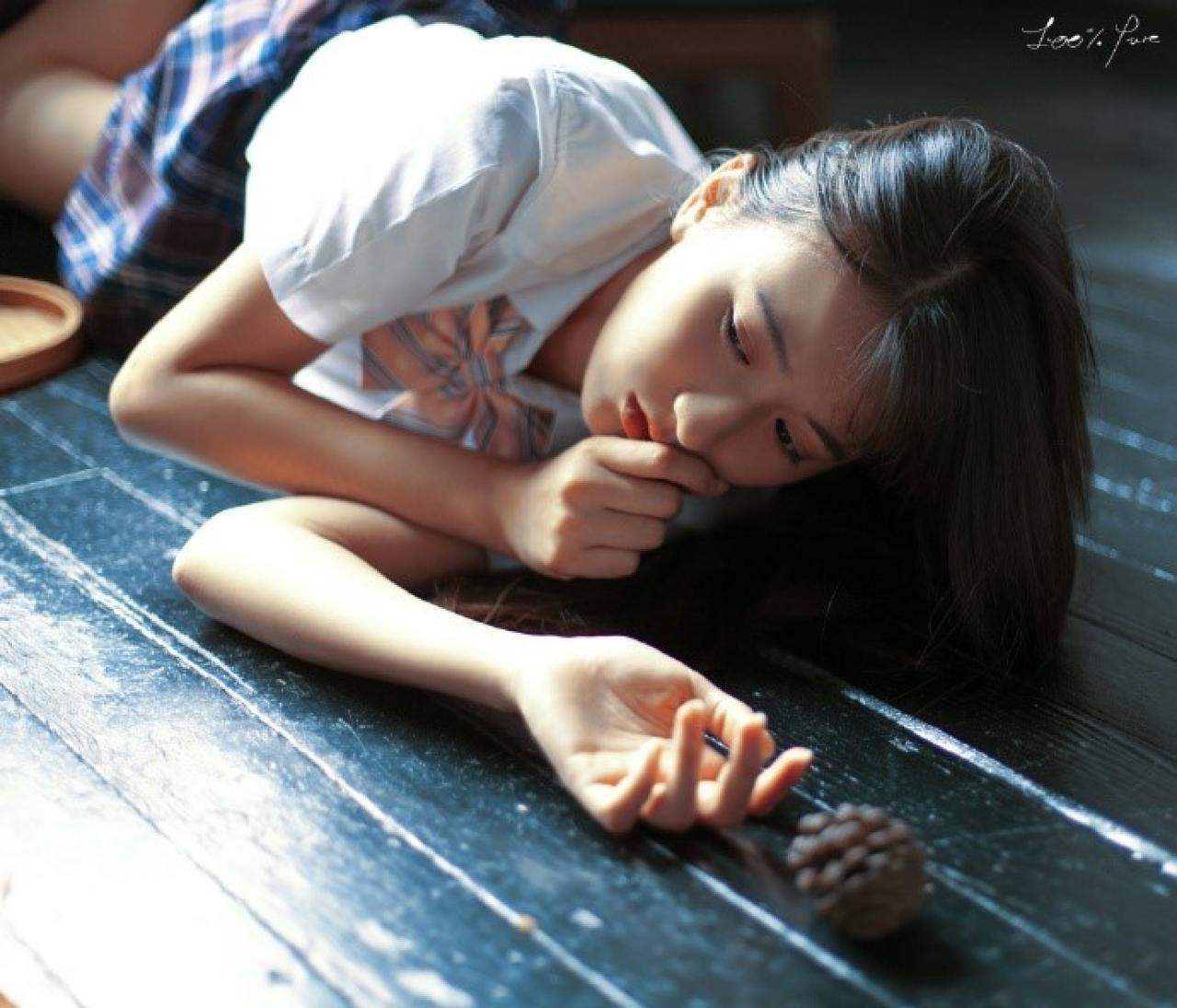 工藤瑶侧身趴在木质地板上，松塔从手中滑落