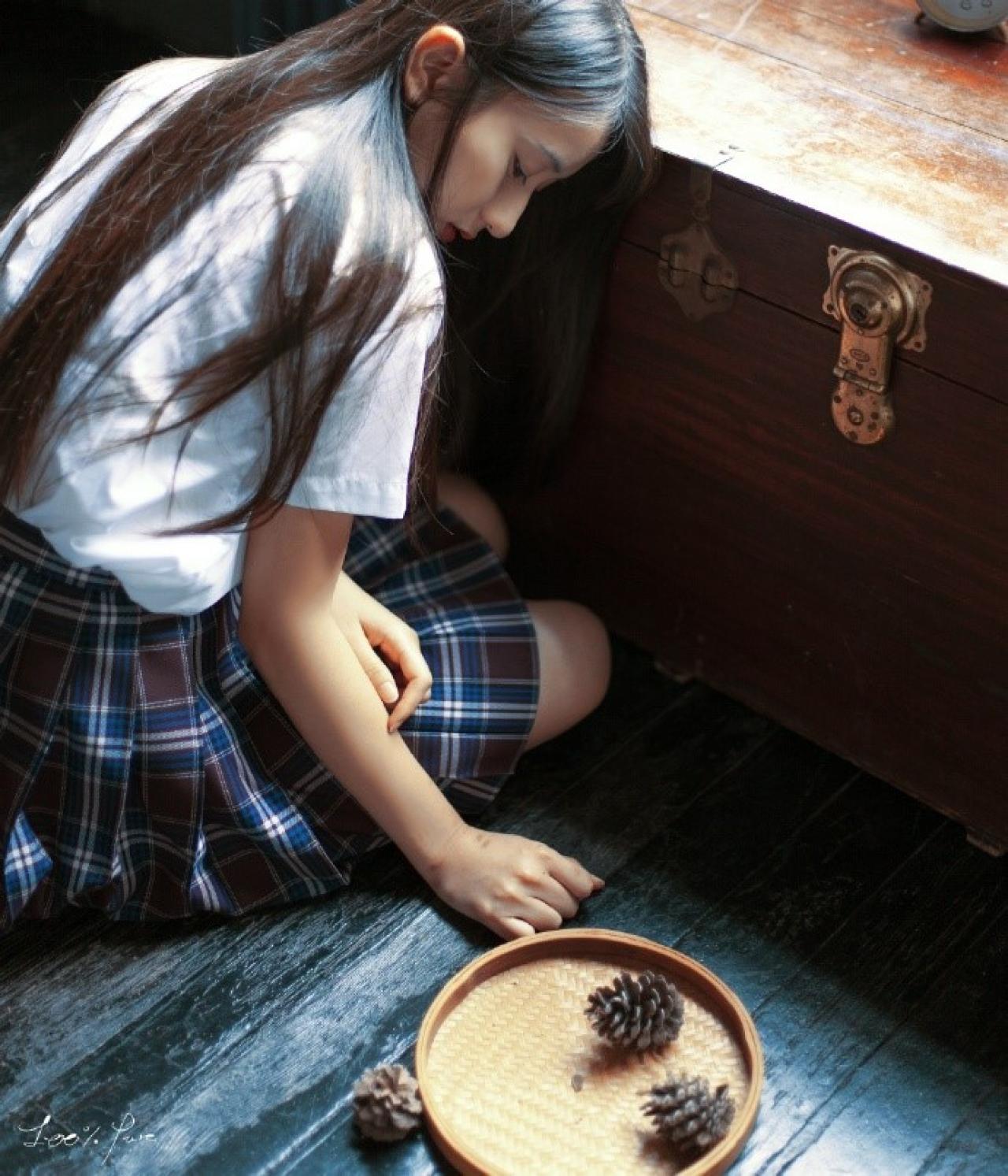 工藤瑶坐在木箱前，侧脸看着盘子里的松塔