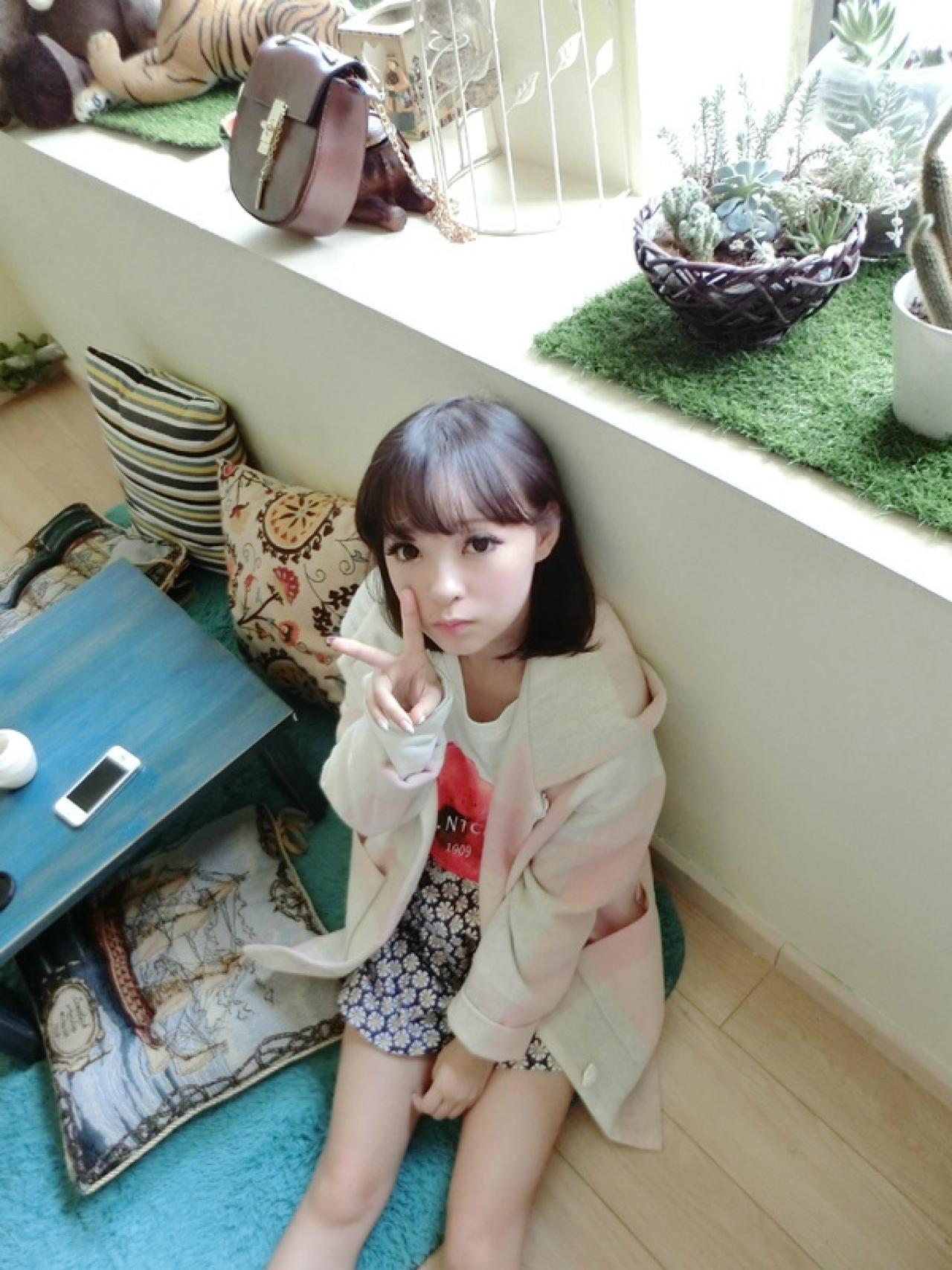 十四娘半靠在墙上，嘟嘴剪刀手卖萌