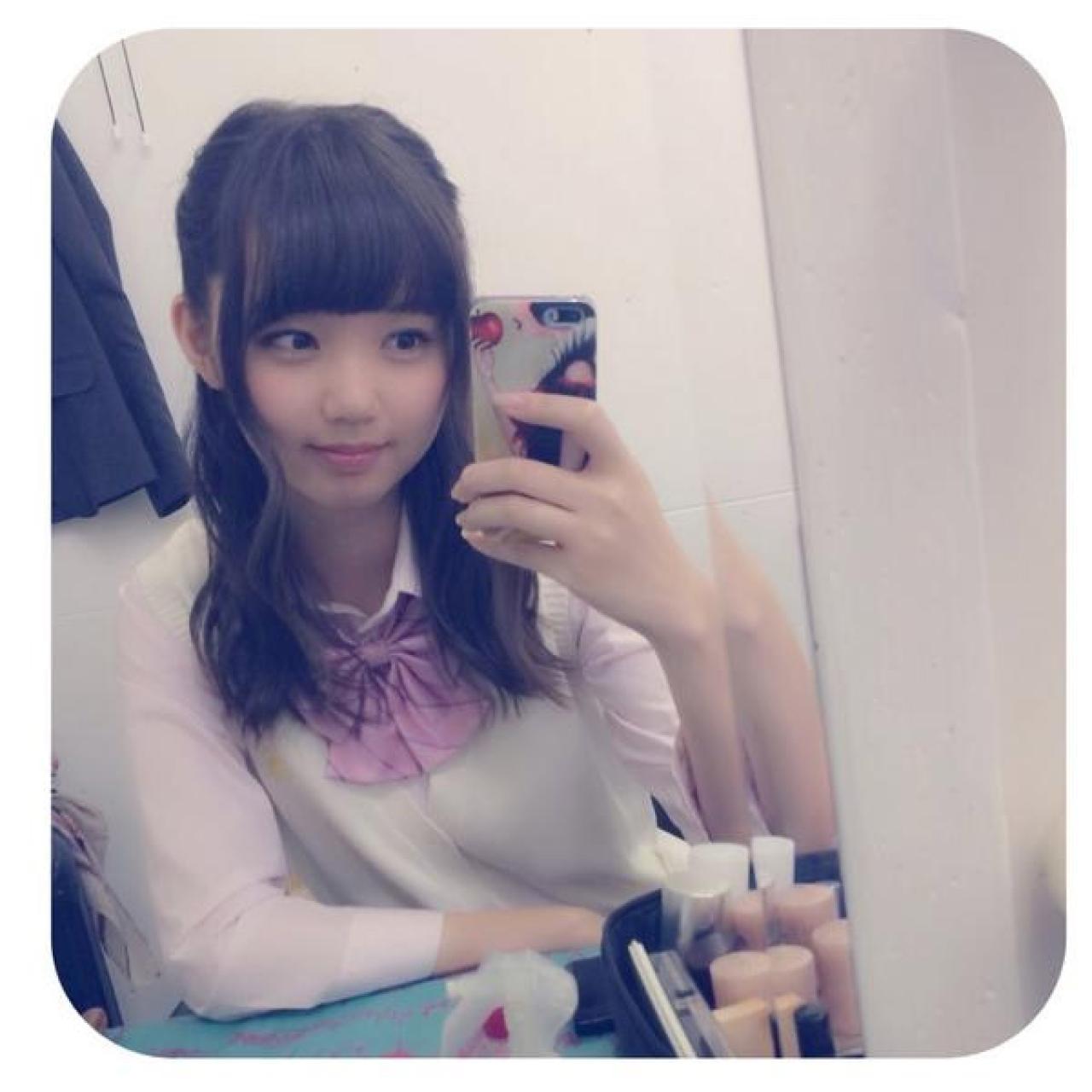 江野沢愛美穿着白色羊毛衫，粉色上衣，戴着粉色蝴蝶结的自拍照