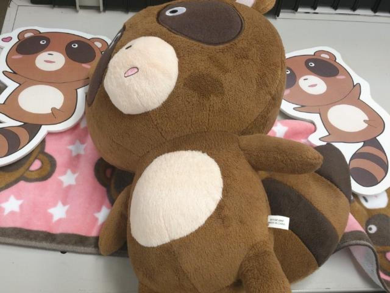 狸猫君娃娃躺在桌子上的样子