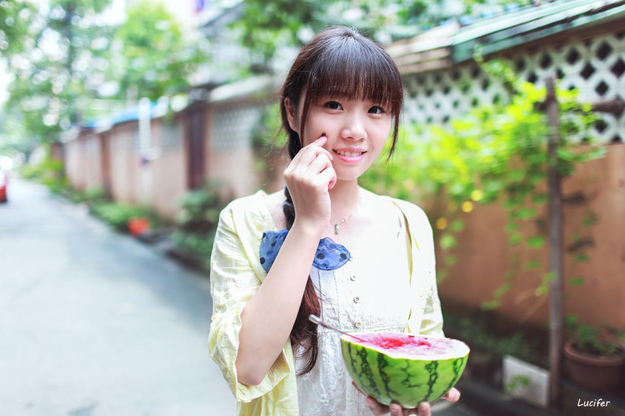 萌妹子拿着半块西瓜，把西瓜籽贴在脸上的姿势