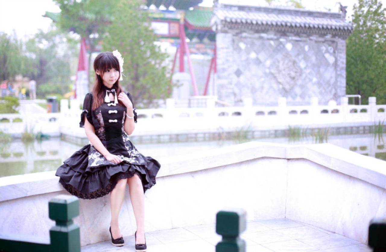青梅素穿着黑色洋装坐在石桥上横幅照
