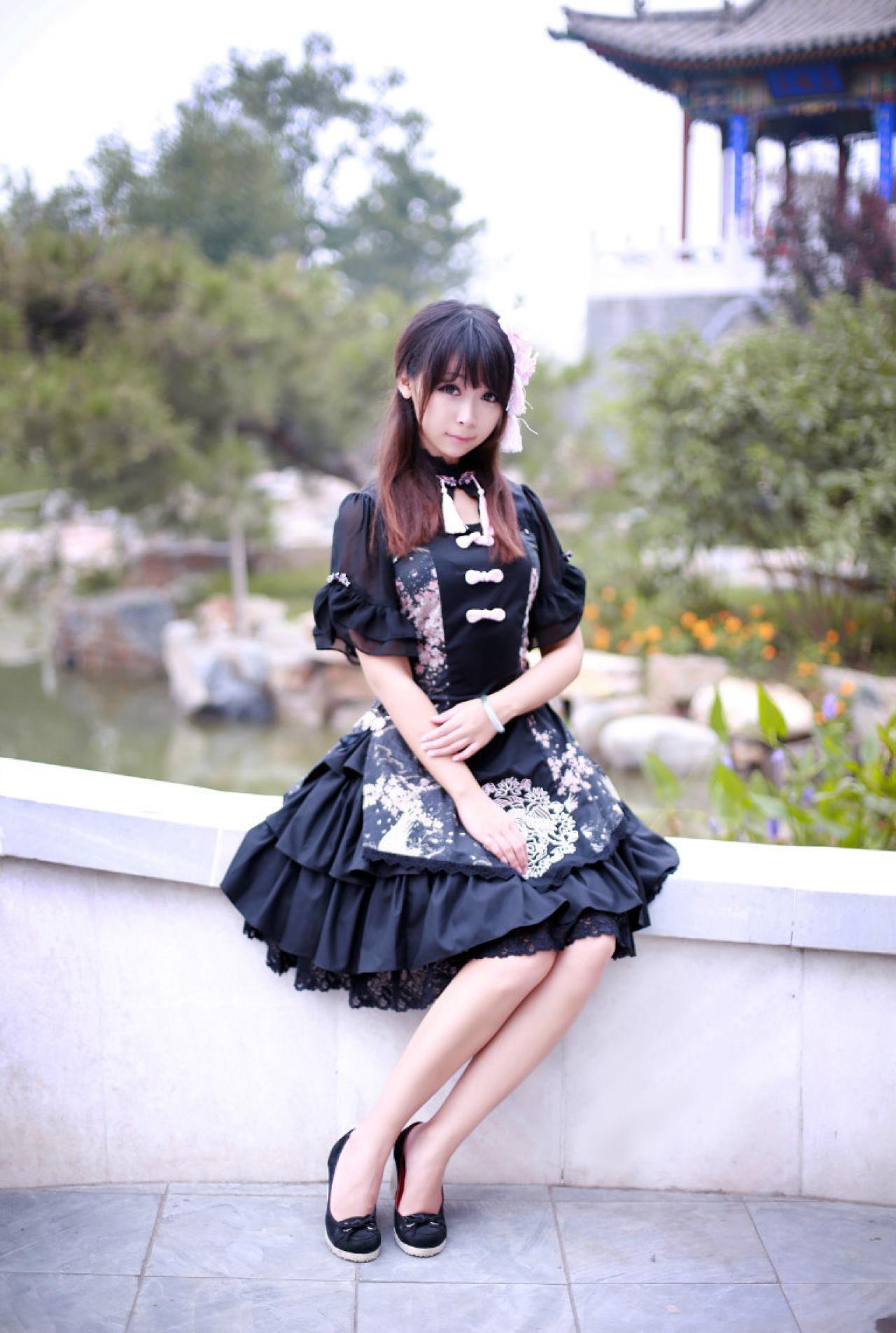青梅素穿着黑色洋装坐在石桥上立幅照
