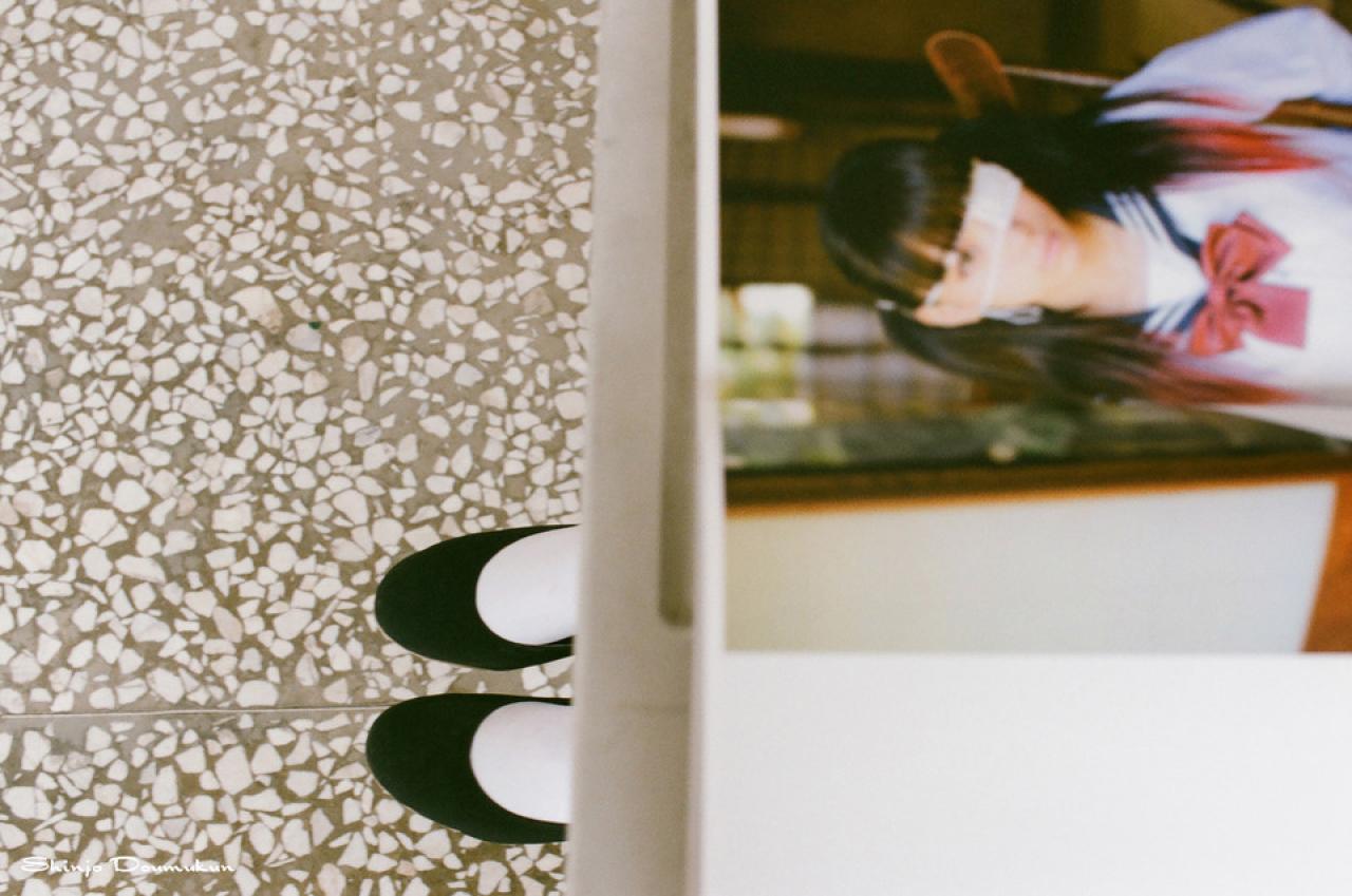 放着萌少女照片的册子和少女露出的双脚