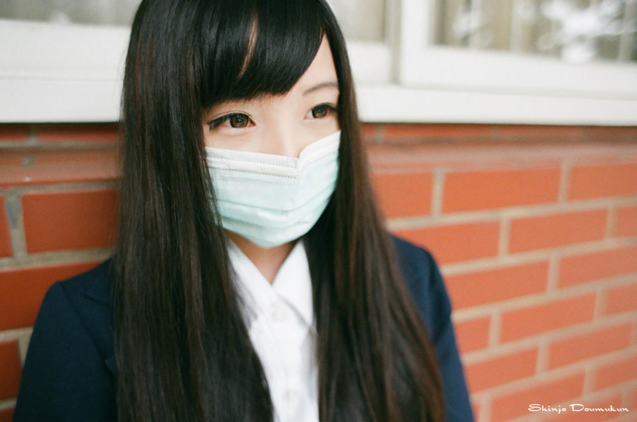 萌少女披着头发戴着口罩靠在墙上的情景