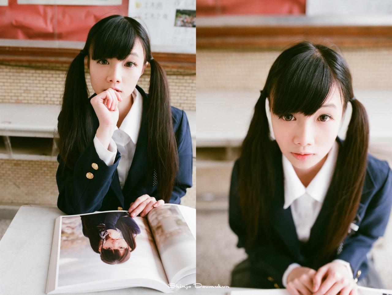 萌少女咬着手指，做着画册中的自己相同的动作