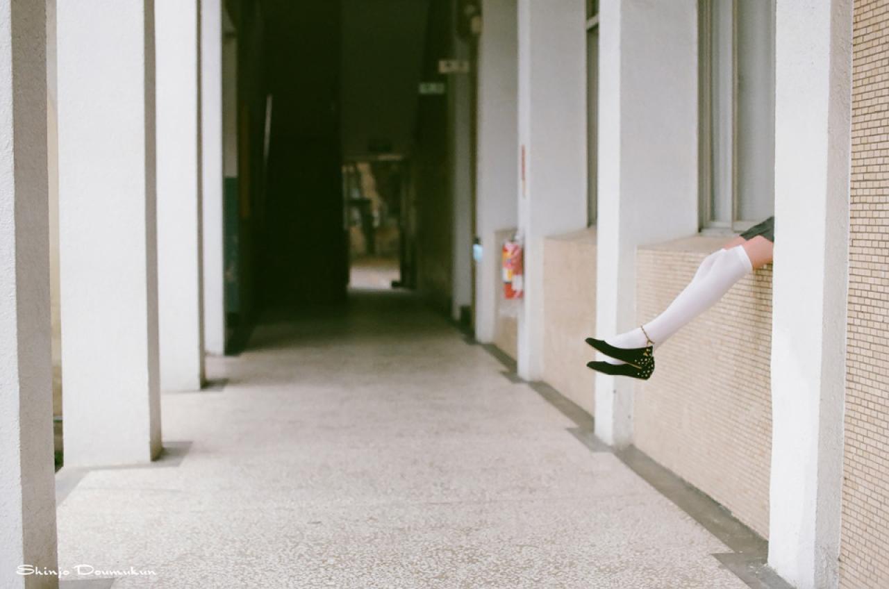 萌少女躺在走廊的窗台上，双脚露在外面