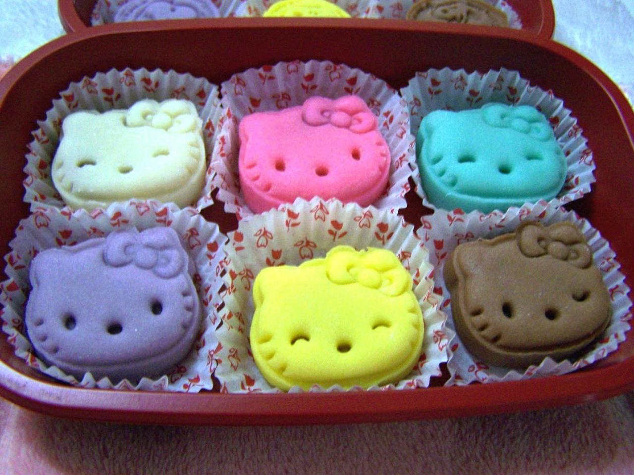六只躺在盒子里枕着纸质包装的不同颜色的纯色HelloKitty月饼
