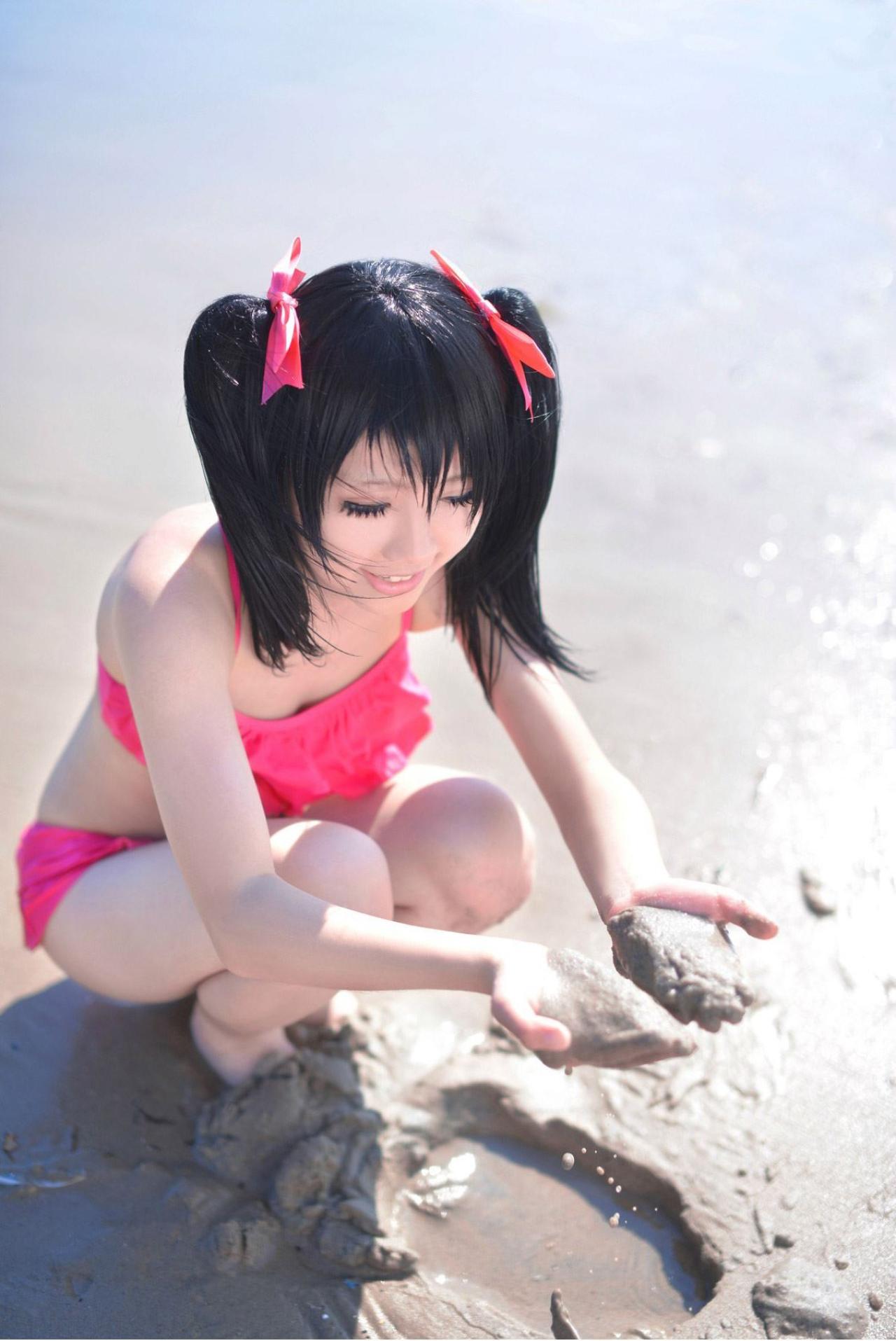 玛丽爷扮演矢泽妮可在海滩活泥巴，两手捧着泥