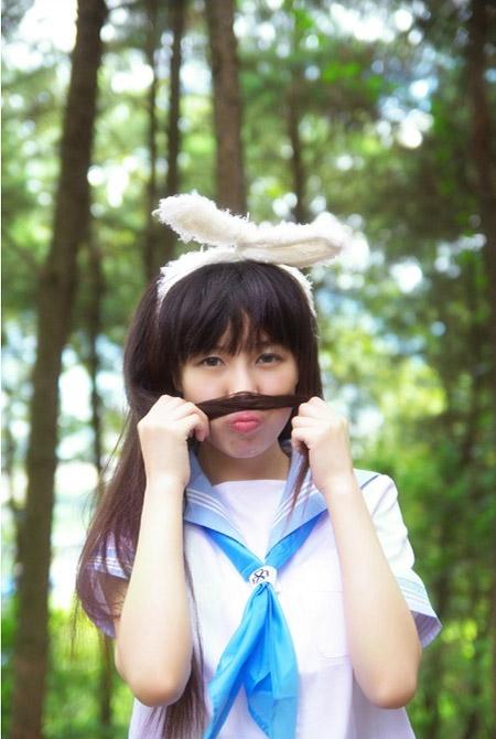 刘兔兔戴着白色兔耳朵，拿着一缕头发贴着鼻子，嘟嘴卖萌