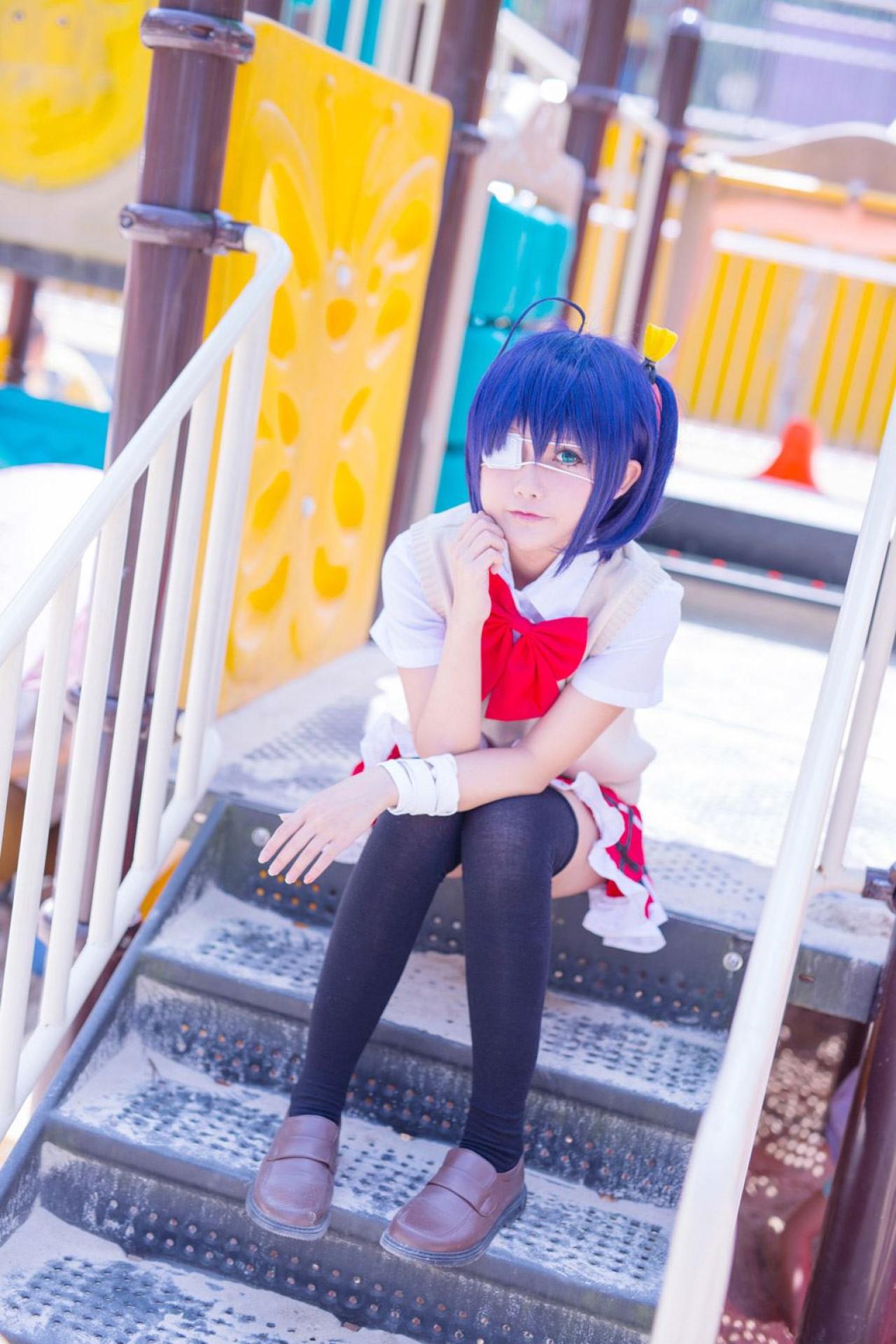 小野麻雀扮演小鸟游六花坐在台阶上轻抚下巴