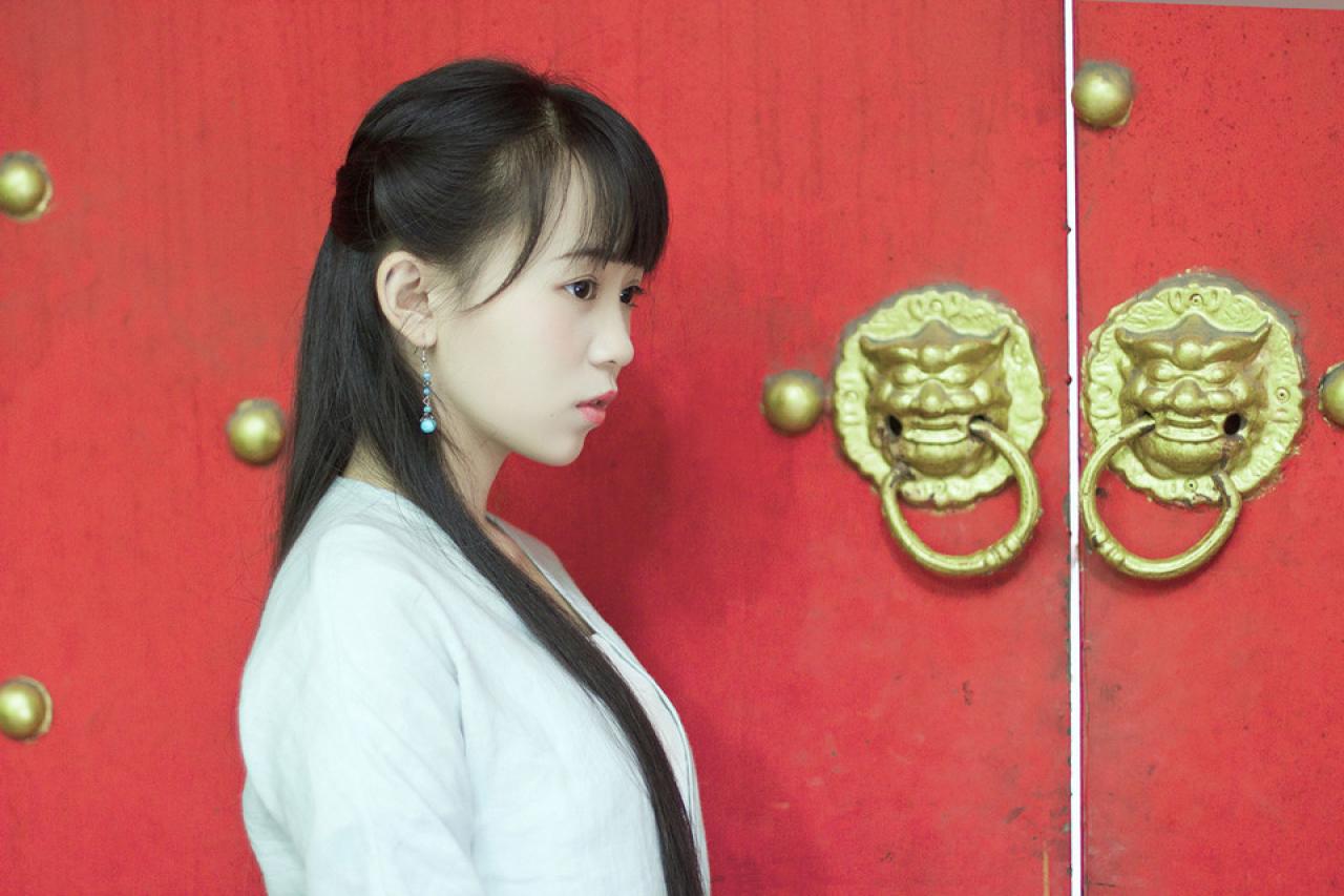 修老虎在红色大门旁失神的侧面