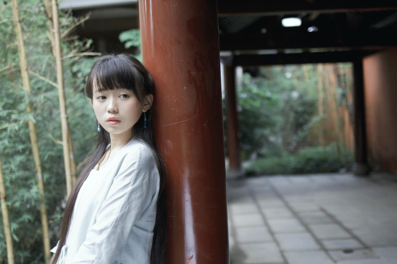 修老虎侧身靠在红色柱子上半身照