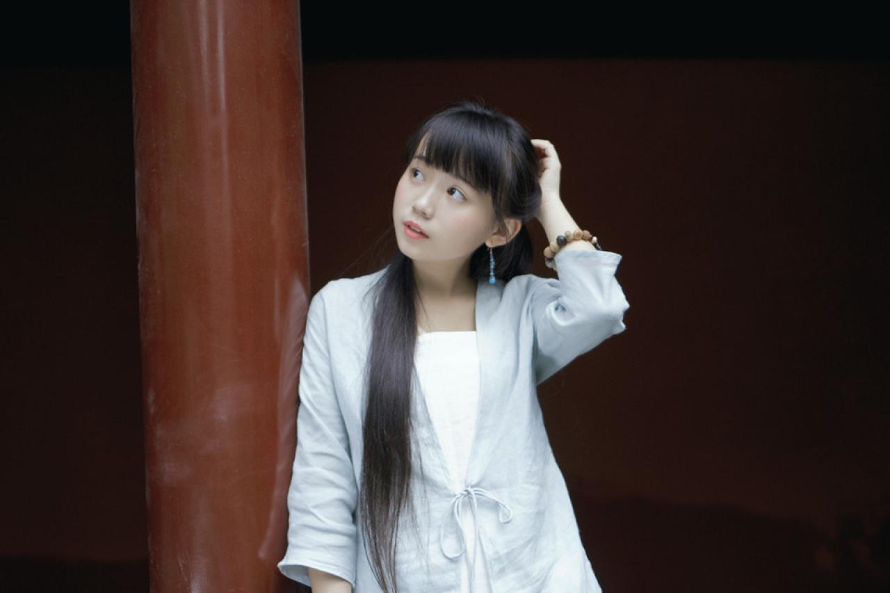 修老虎靠在红色柱子上，轻抚脑后