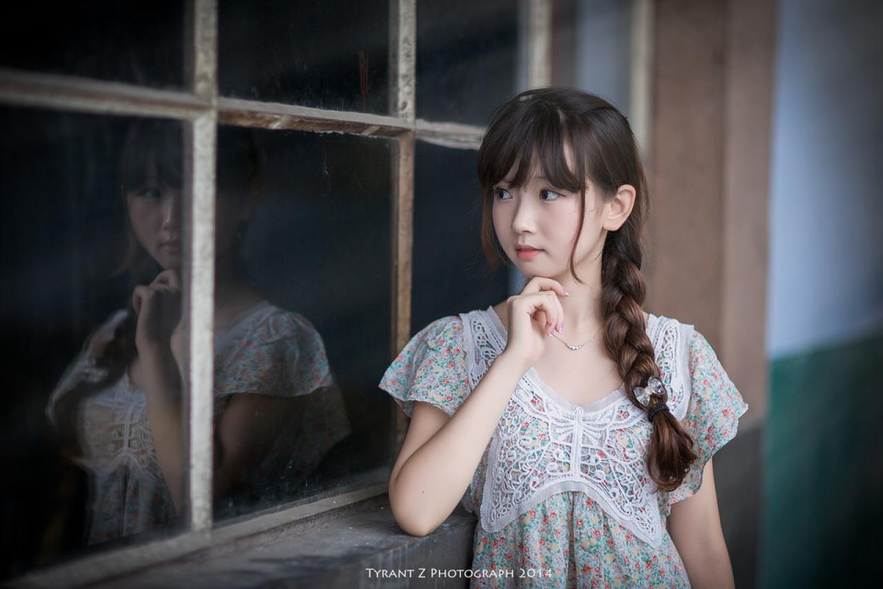 小圆脸雪雪在走廊的格窗前，扒在窗台