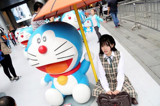 彩虹姐姐坐在哆啦A梦的伞底下微侧面照