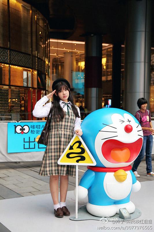 彩虹姐姐扶着哆啦A梦的转弯路标上敬个礼