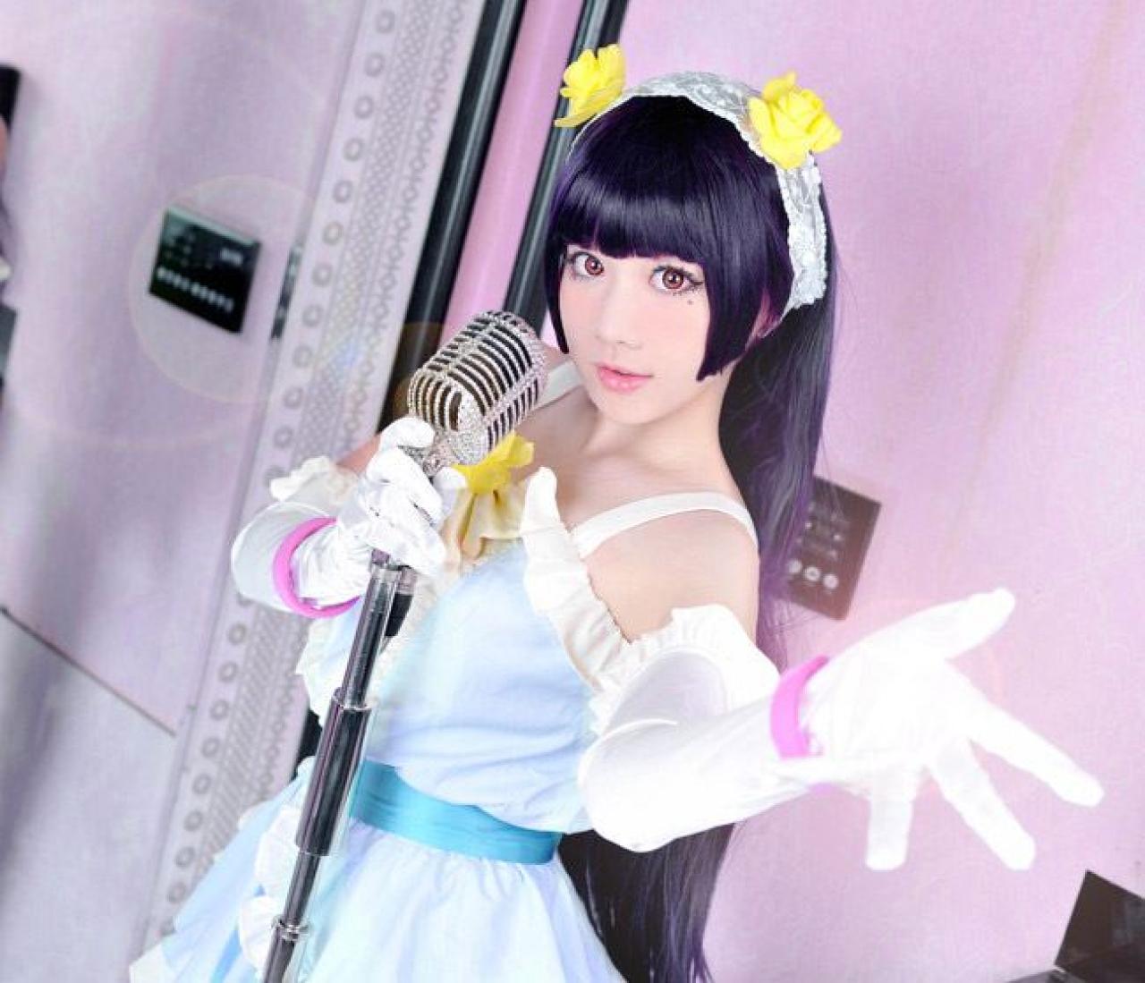 deerM小樱花扮演五更琉璃右手握着话筒，左手伸出