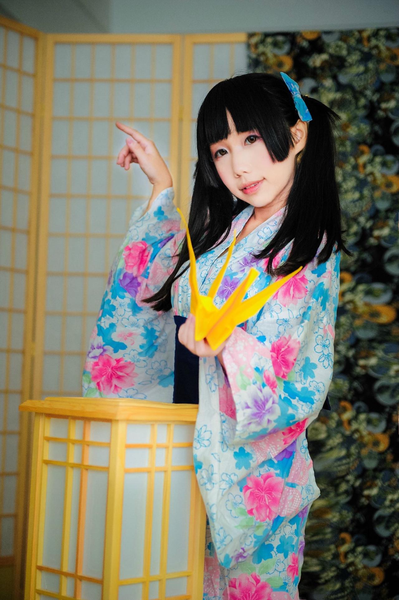 七喵穿着浴衣靠在灯箱旁，左手拿着黄色千纸鹤