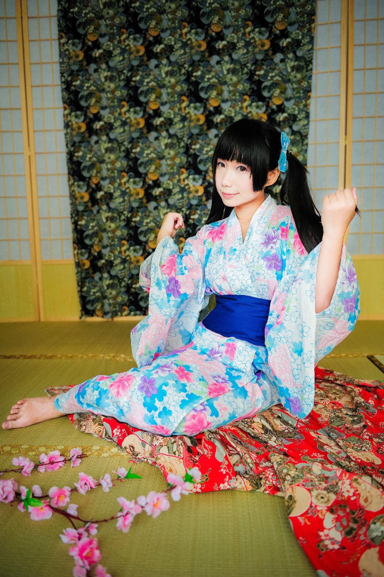 七喵穿着浴衣坐在地上，双手抬起