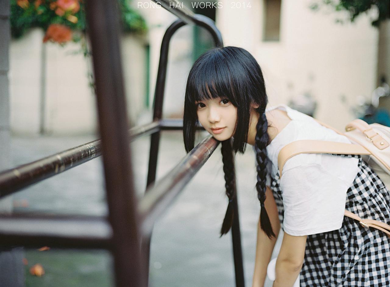 双马尾辫萌妹子弓腰把下巴贴在栏杆上