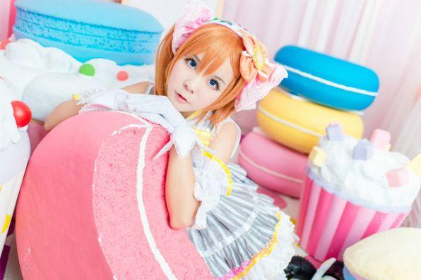 Candi糖糖扮演高坂穗乃果穿着灰色打歌服扒在巨型“甜点”上