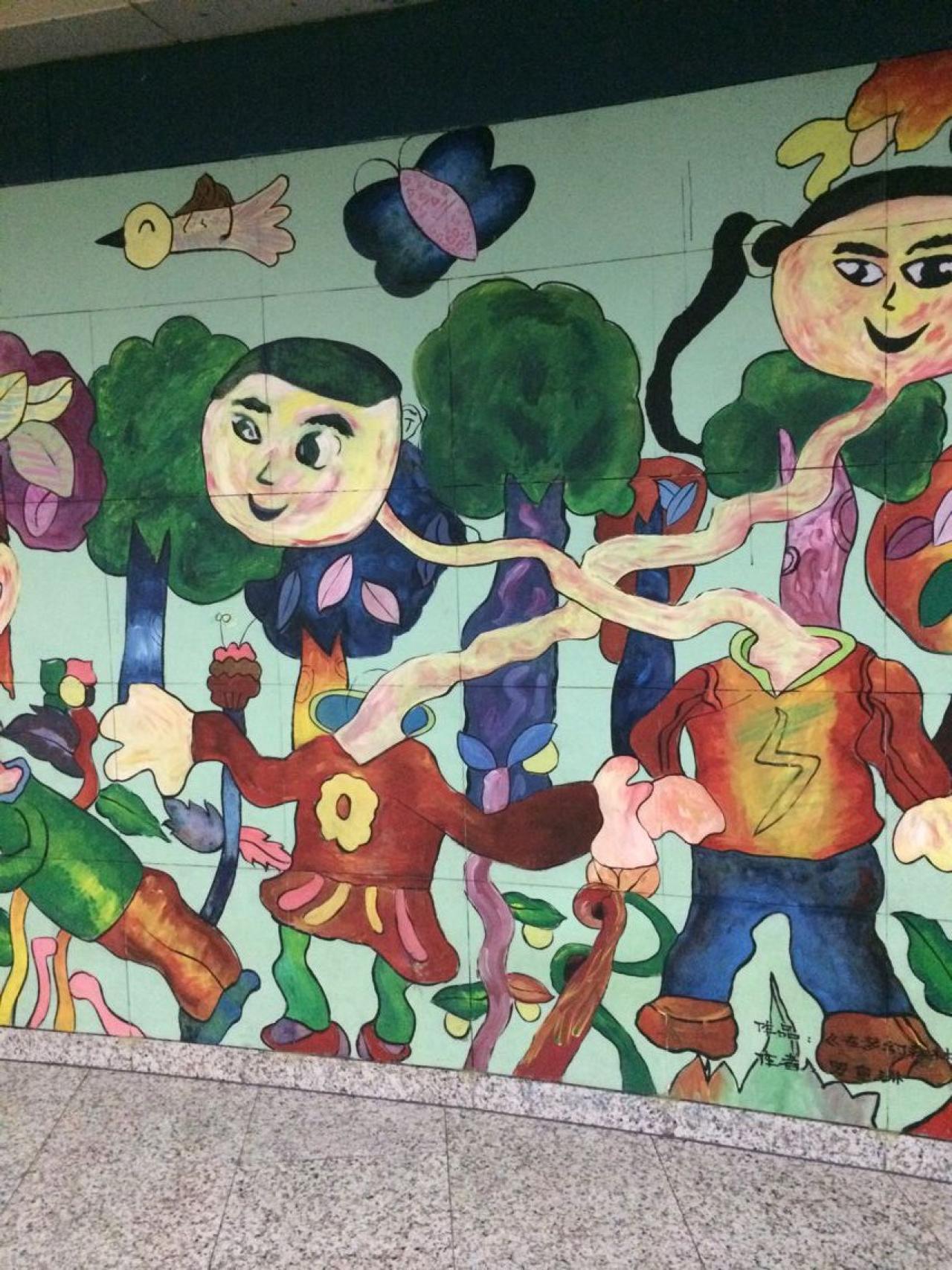 重庆地铁站的墙面印着小朋友的儿童画作品《在梦幻森林一起吸氧的小朋友》 阿奴ww拍摄